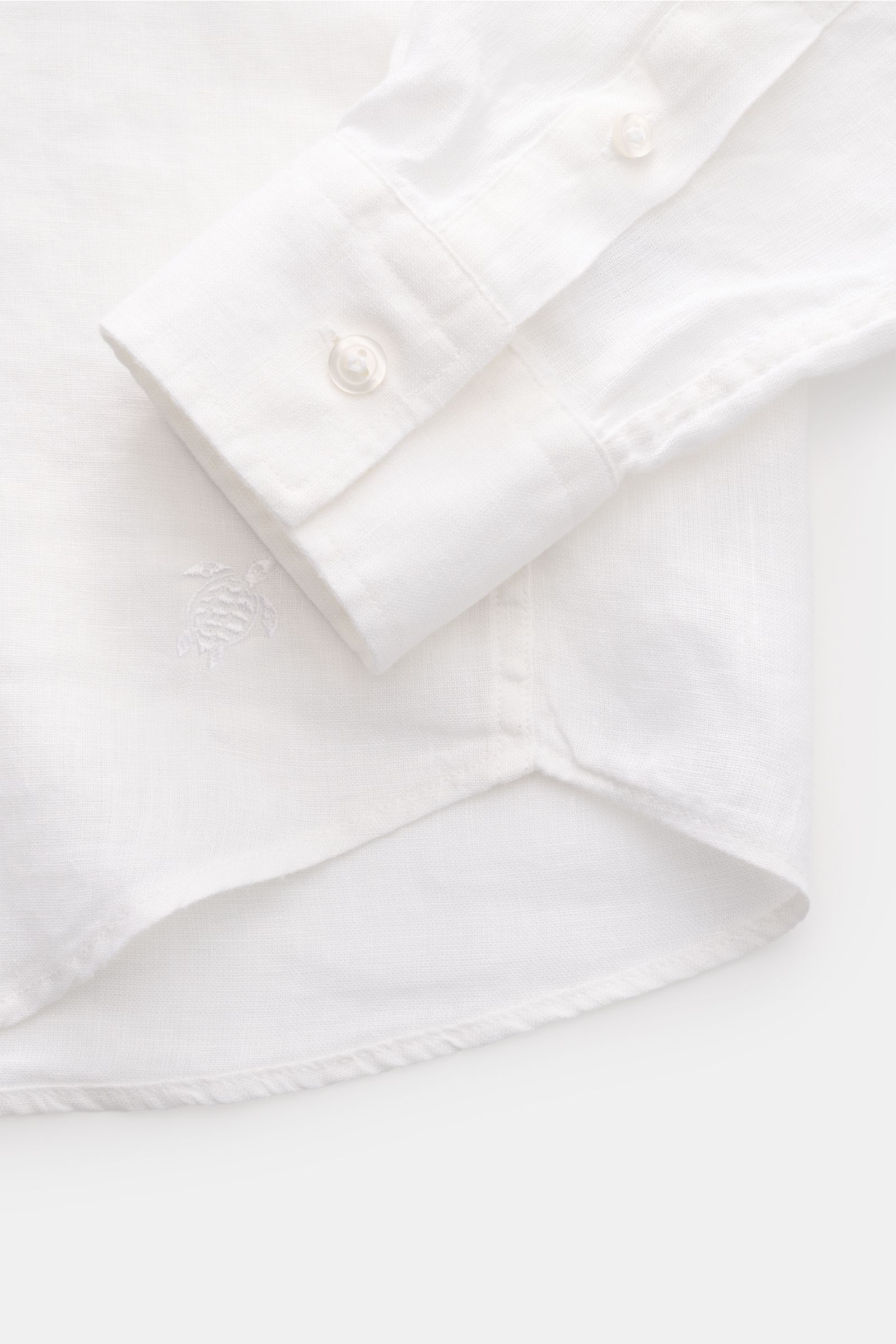 Vilebrequin Leinenhemd schmaler Kragen weiß, Detailansicht von Manschette und Saum, leichte Qualität, weicher Griff, Regular Fit, französische Knopfleiste, klassische Sportmanschette, aufgesetzte Brusttasche, gerundeter Saumverlauf, tonales Stitching am S