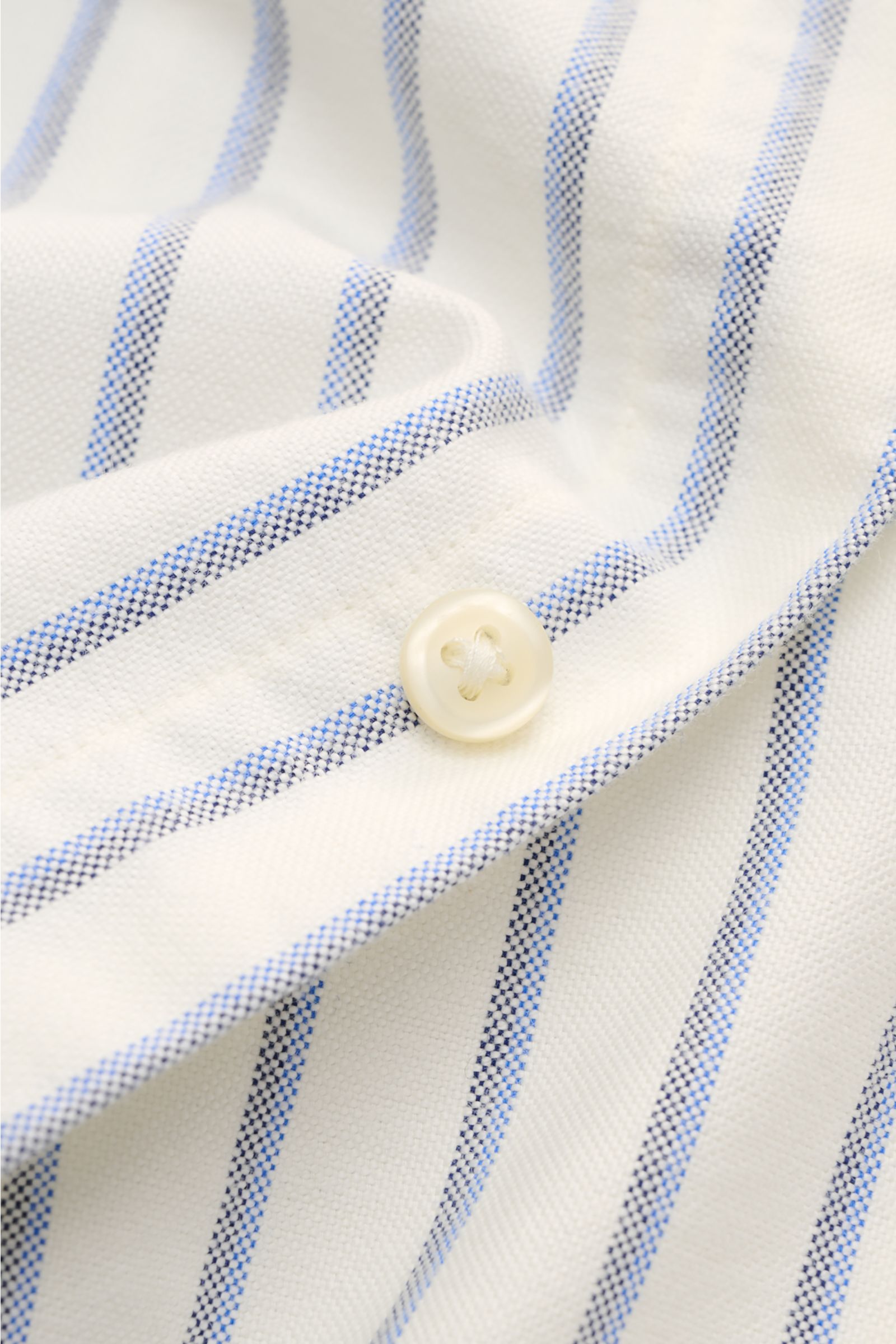 Nahaufnahme aus schräger Perspektive des Polo Ralph Lauren Oxford-Hemd Button-Down-Kragen offwhite/blau/schwarz gestreift mit weichem Griff, reiner Baumwolle, Knopf und klassischem Streifenmuster.