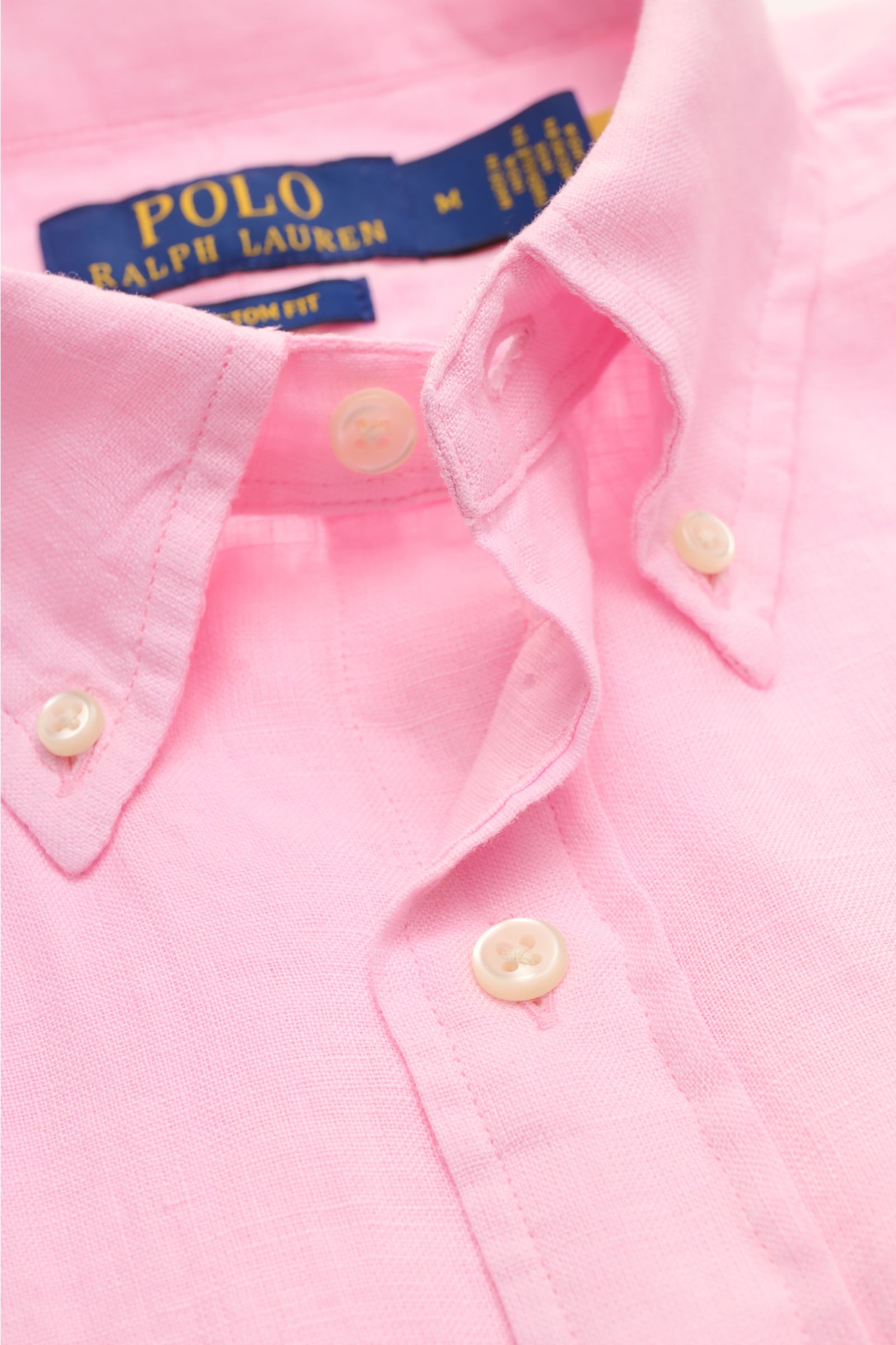 Nahaufnahme von Polo Ralph Lauren Leinenhemd Button-Down-Kragen rosé aus atmungsaktivem Leinen mit weichem Griff und Polospieler-Stitching.