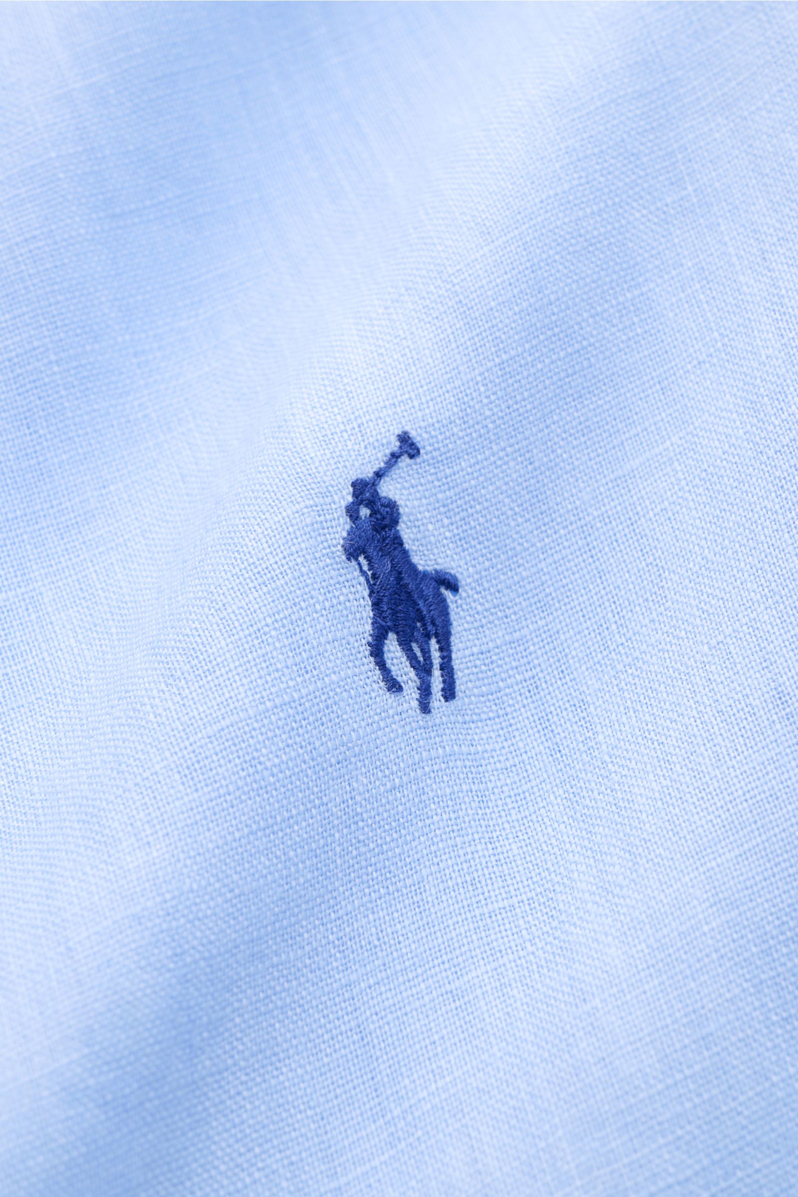 Nahaufnahme des Polo Ralph Lauren Leinenhemd Button-Down-Kragen hellblau mit markentypischem Polospieler-Stitching aus reinem Leinen in leichter Qualität.