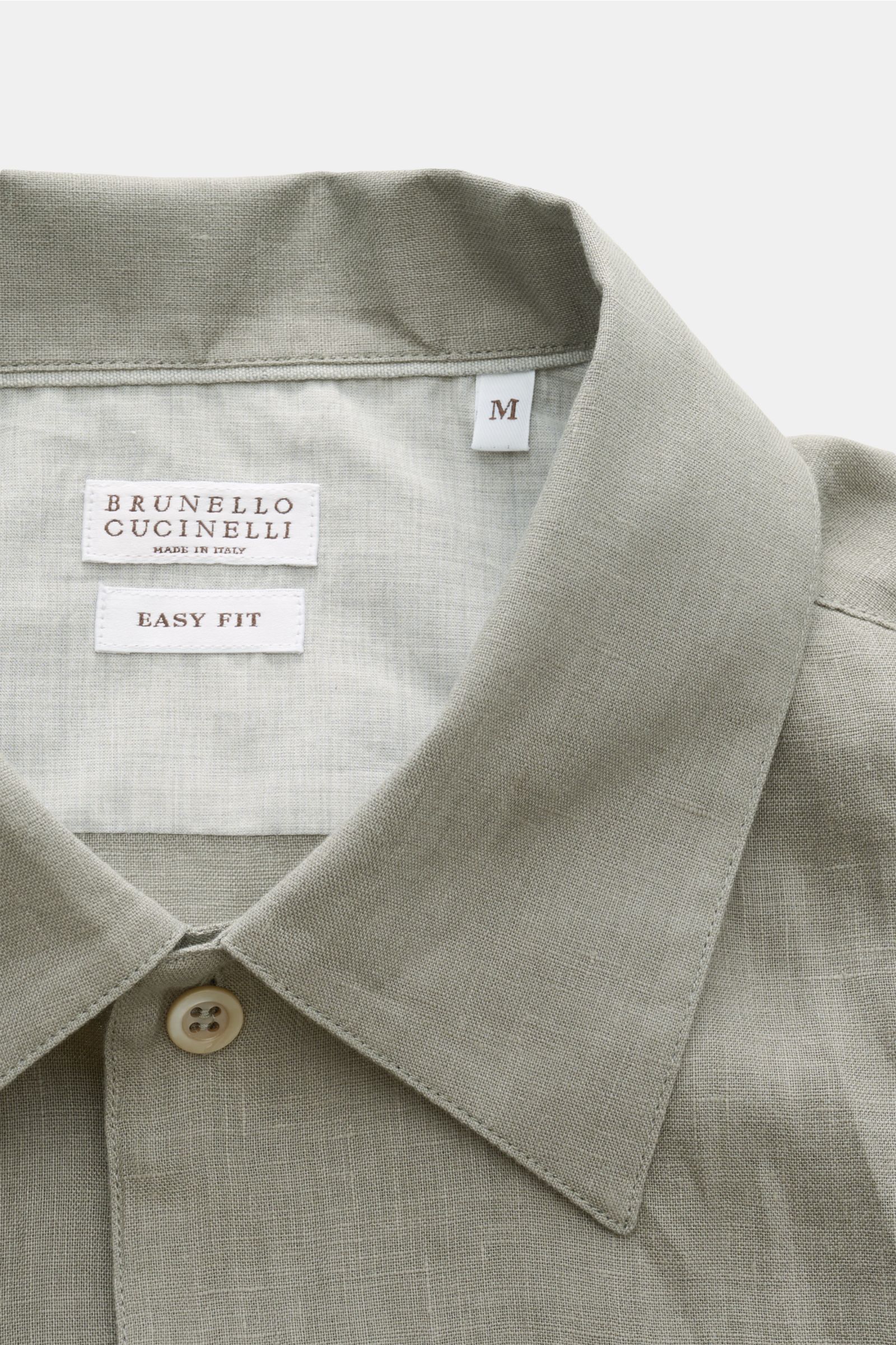 Close-up front view of the collar and label of the Brunello Cucinelli Leinenhemd Haifisch-Kragen salbei in light sage.

Feinste Leinenqualität: Das sommerlich-leichte Hemd mit Haifischkragen aus dem Hause BRUNELLO CUCINELLI überzeugt mit luxuriösem Tra