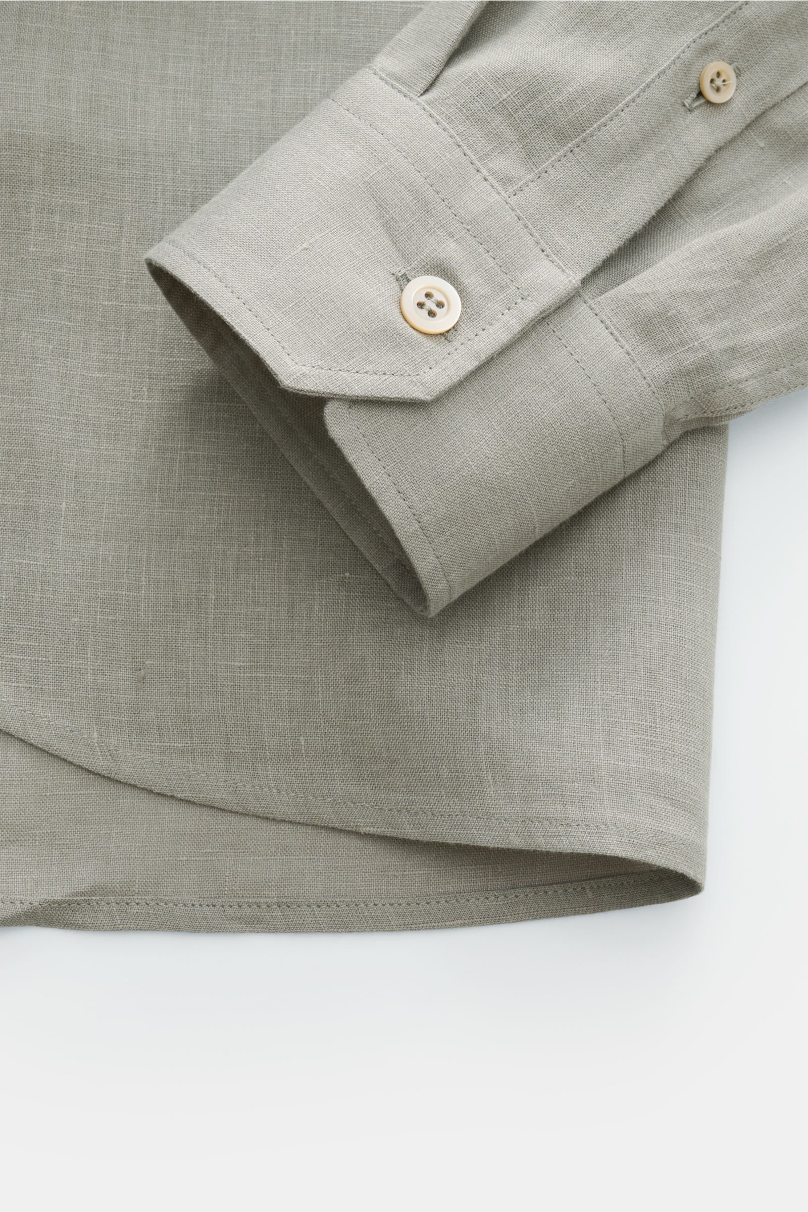 Close-up view of the cuff and hem of the Brunello Cucinelli Leinenhemd Haifisch-Kragen salbei, showcasing fine linen texture and mother-of-pearl button.

Feinste Leinenqualität: Das sommerlich-leichte Hemd mit Haifischkragen aus dem Hause BRUNELLO CUCI