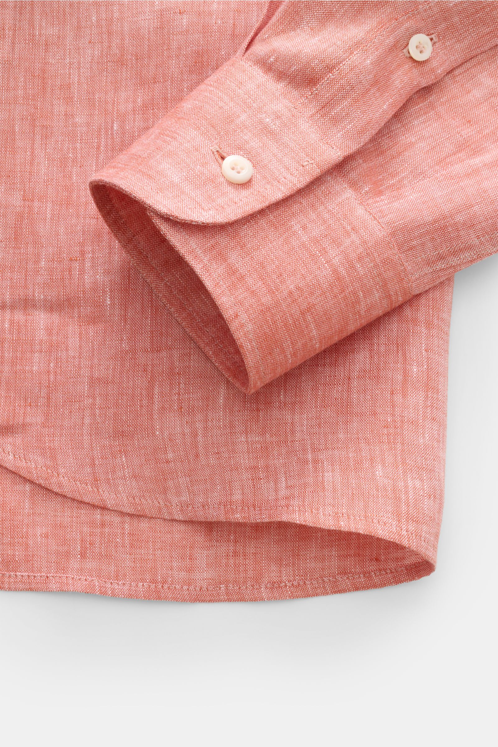 Close-up side view of the cuff and hem of the Brunello Cucinelli Leinenhemd Haifisch-Kragen hellrot meliert, a summer-light linen shirt with shark collar, featuring pure linen, typical material texture, regular fit, patch button placket with mother-of-pea