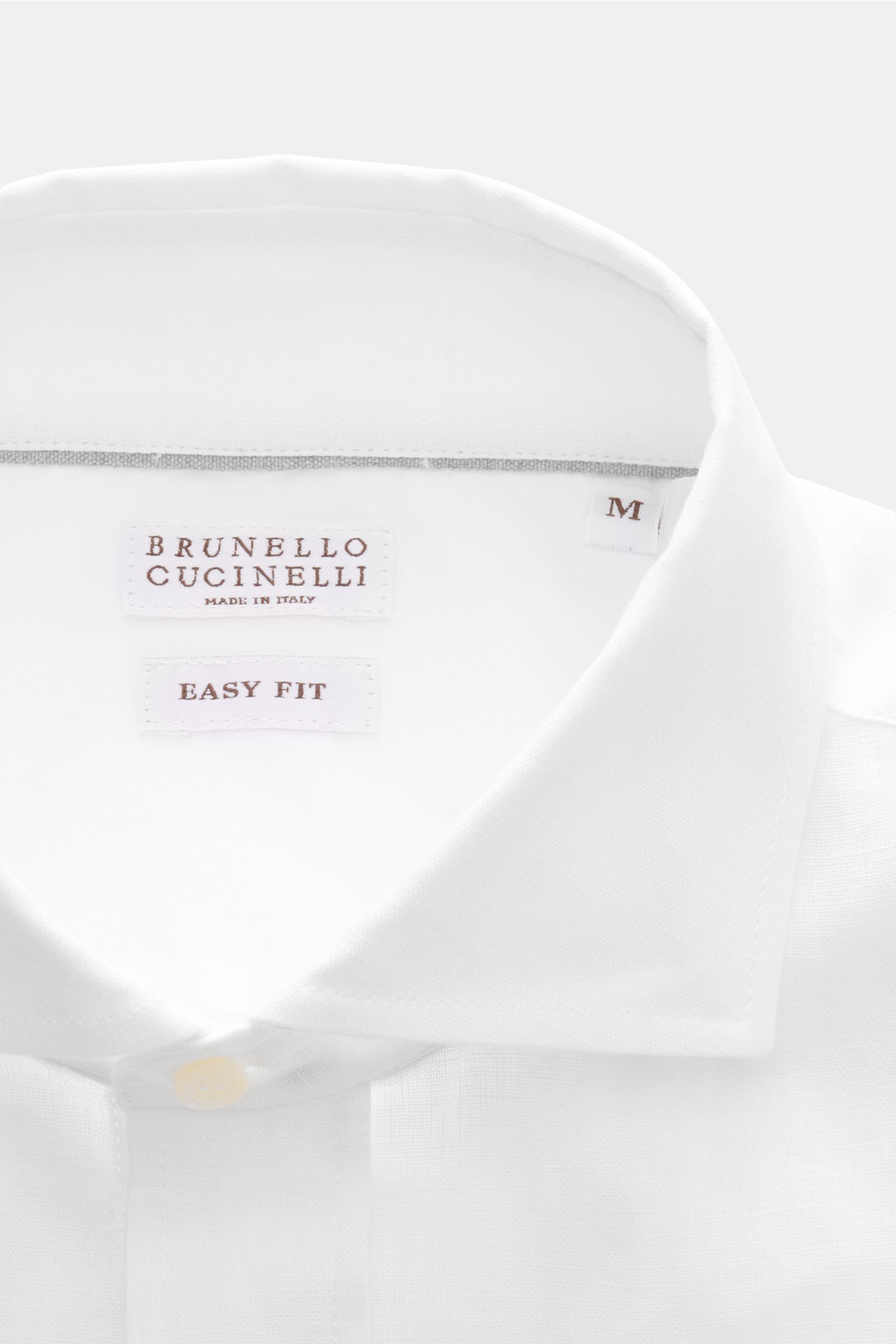 Close-up front view of the Brunello Cucinelli Leinenhemd Haifisch-Kragen weiß, showcasing fine linen fabric with shark collar and mother-of-pearl buttons. Feinste Leinenqualität: Das sommerlich-leichte Hemd mit Haifischkragen aus dem Hause BRUNELLO CUC
