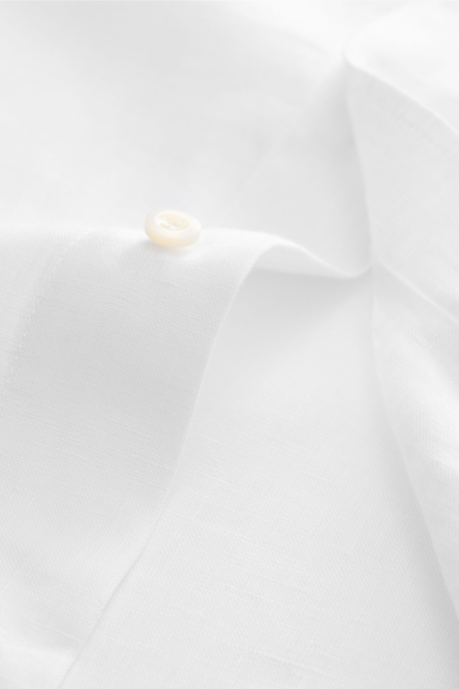 Close-up of the cuff and button of the Brunello Cucinelli Leinenhemd Haifisch-Kragen weiß, photographed from a side angle.

Feinste Leinenqualität: Das sommerlich-leichte Hemd mit Haifischkragen aus dem Hause BRUNELLO CUCINELLI überzeugt mit luxuriösem