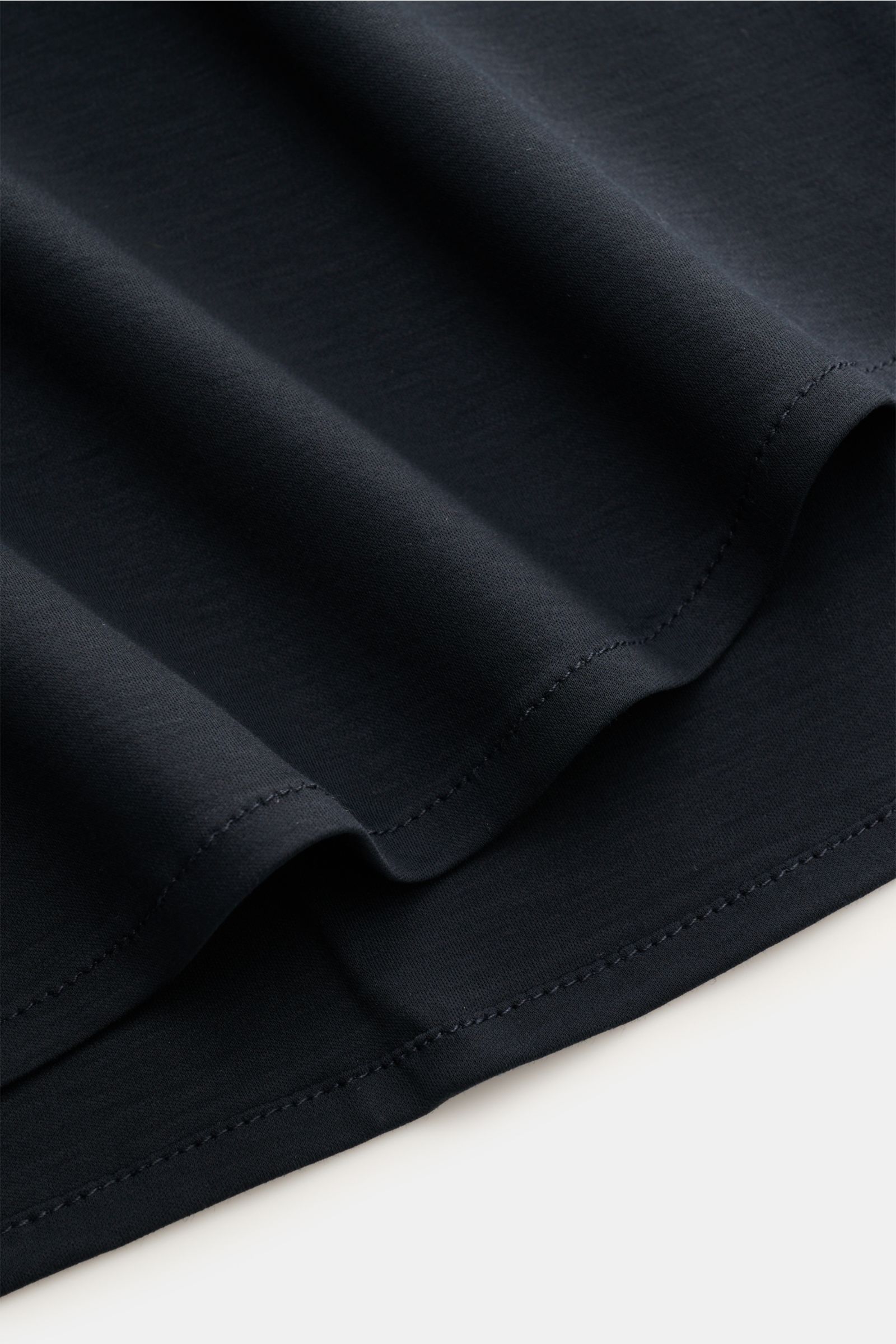 Nahaufnahme des navyfarbenen Stefan Brandt Jersey-Hemd 'Otis' Haifisch-Kragen, zeigt glatten, flexiblen Jersey aus reiner Pima-Baumwolle mit gerundetem Saum.