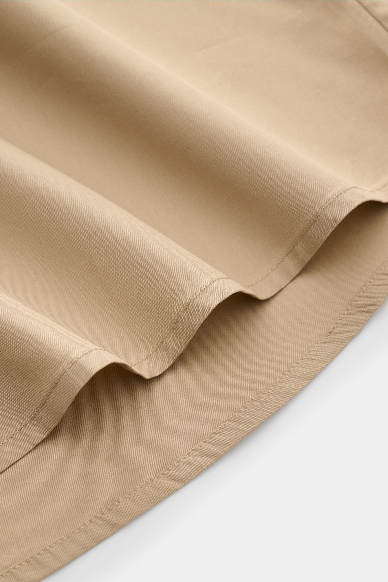 Close-up of the hem of the A.P.C. Kurzarmhemd Kent-Kragen sand, showing its slightly rounded hemline and smooth cotton fabric from a side angle.

The product is a classic, modern short-sleeve shirt by A.P.C. in sand color, made of pure cotton with a smoot