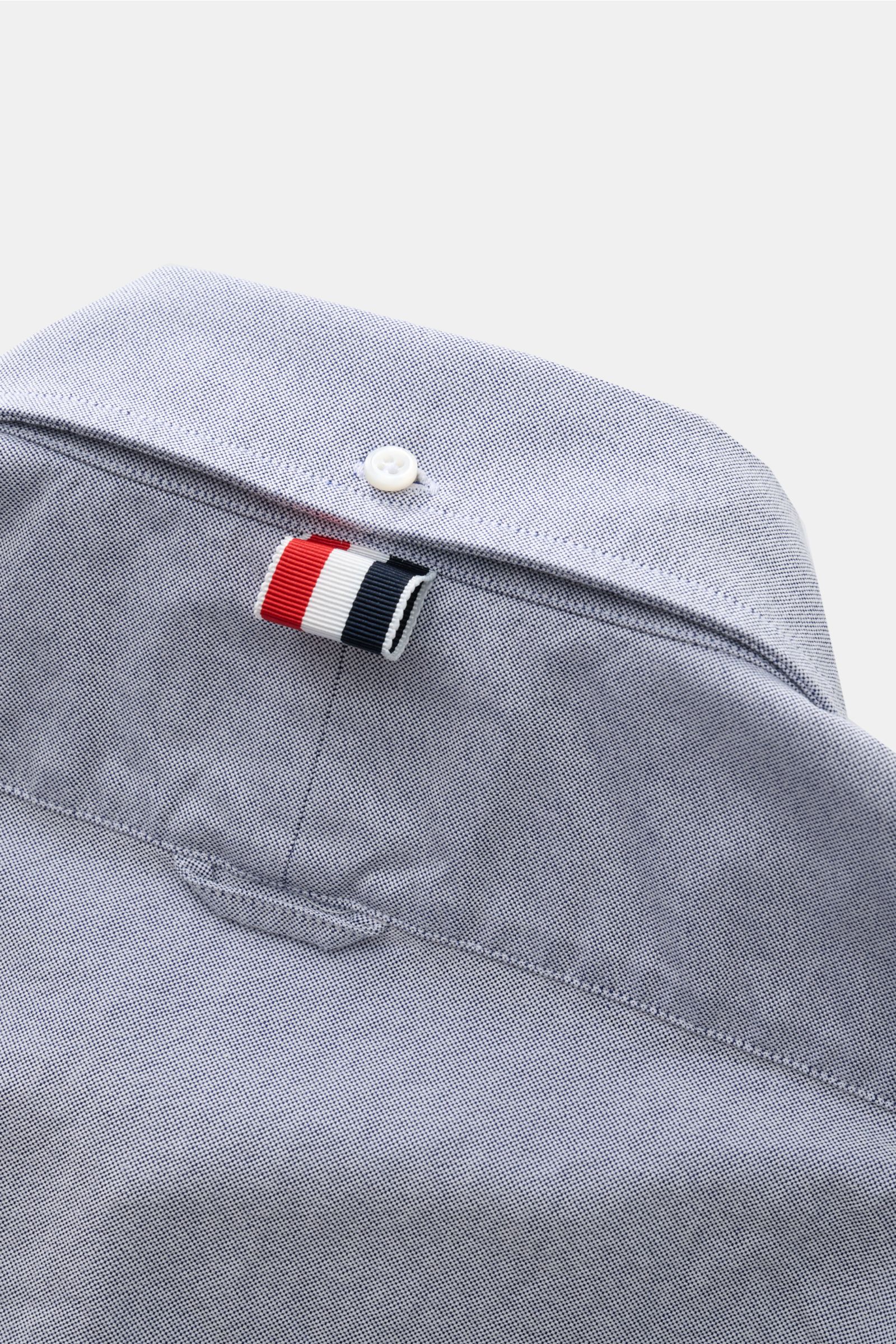 Nahaufnahme des rückwärtigen Kragenbereichs des Thom Browne Kurzarmhemd Button-Down-Kragen rauchblau aus Baumwoll-Oxford mit weichem Griff, Rückenpasse, Quetschfalte und markantem rot-weiß-blauem Aufhänger.