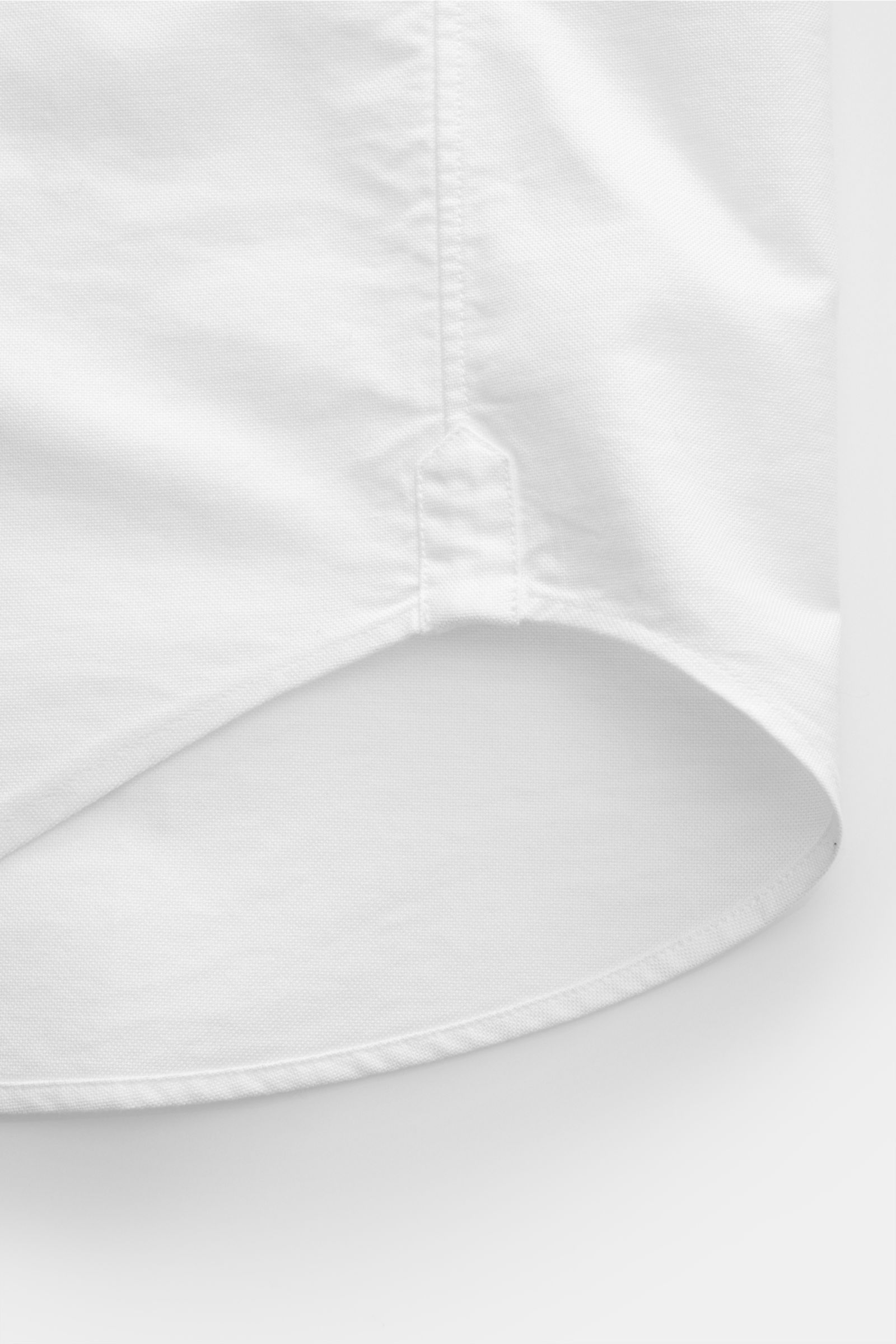 Close-up view of the slightly rounded hem of the Thom Browne Short-sleeve shirt button-down collar white, made from pure cotton Oxford fabric with soft feel and regular fit.
