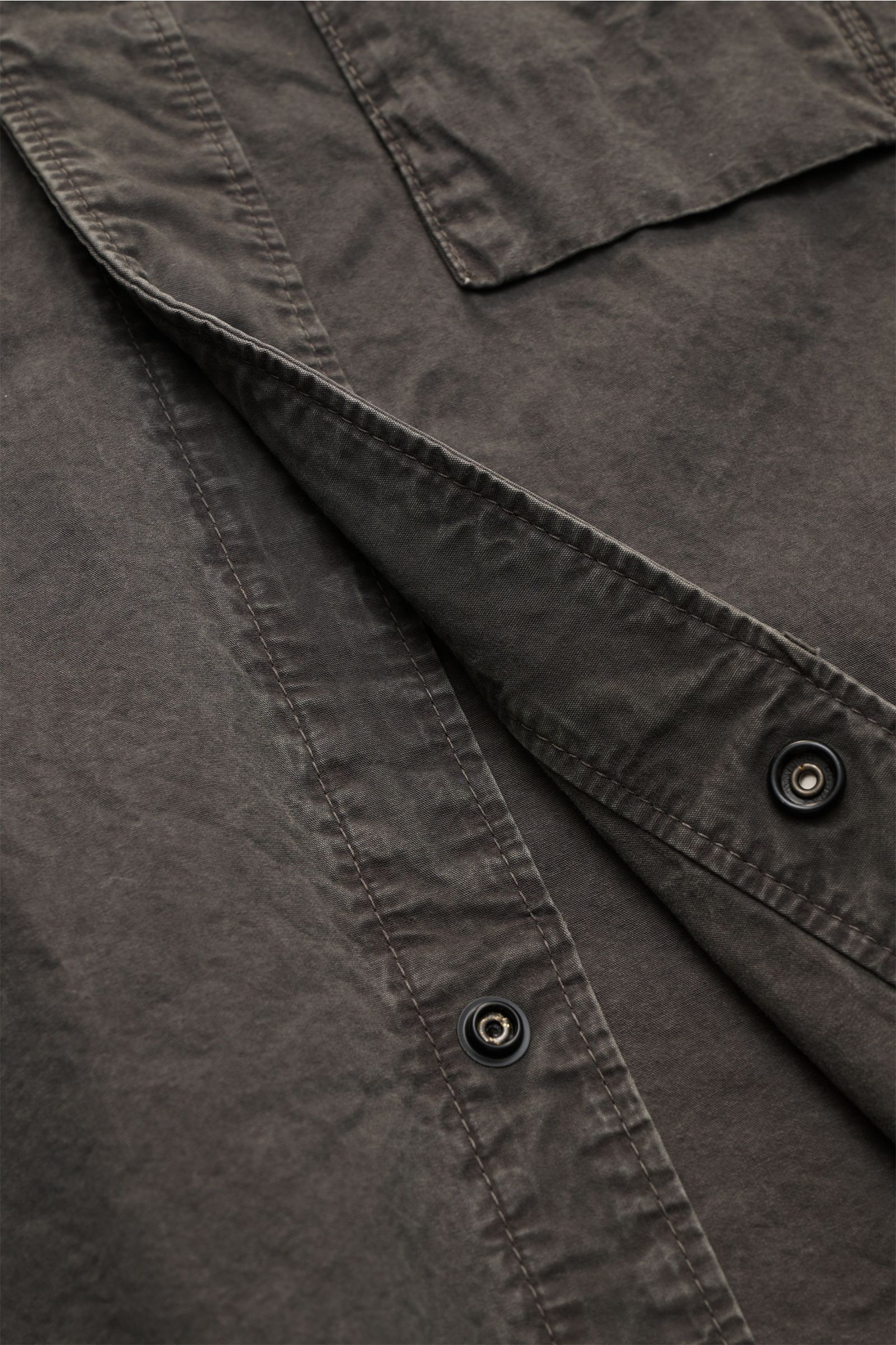 Close-up front view of the Stone Island Short sleeve shirt 'Brushed Canvas' Kent collar anthracite, showing garment-dyed pure organic cotton fabric, concealed snap button closure, and textured soft canvas with a relaxed fit. Versatility and urban style: T