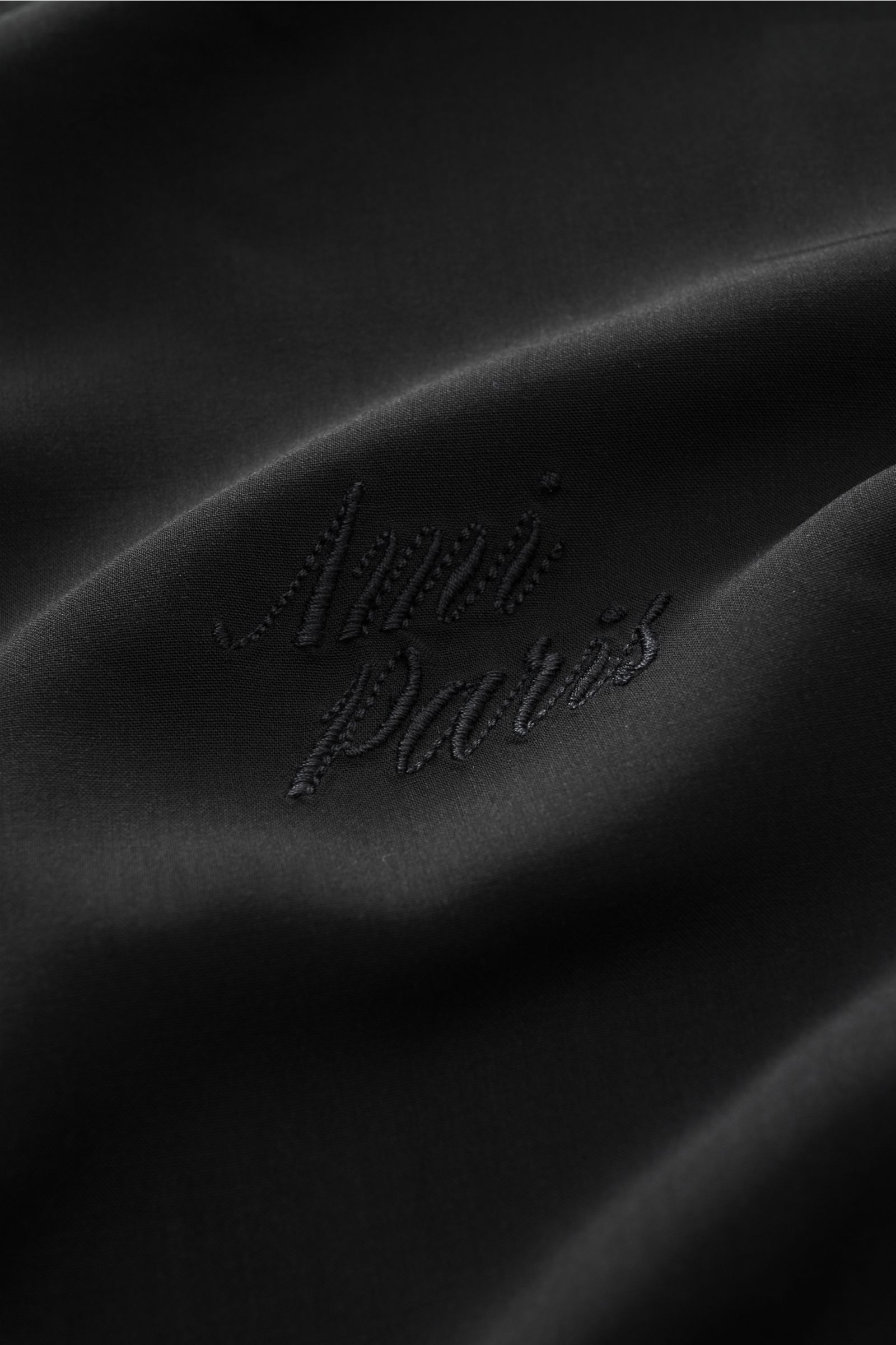Ami Paris Short sleeve shirt 'Boxy' Cuban collar black shown in close-up from above, highlighting logo stitching on soft pure viscose fabric. Modern and casual: With its 'Boxy' fit, this short sleeve shirt by AMI PARIS is an uncomplicated key piece for sp