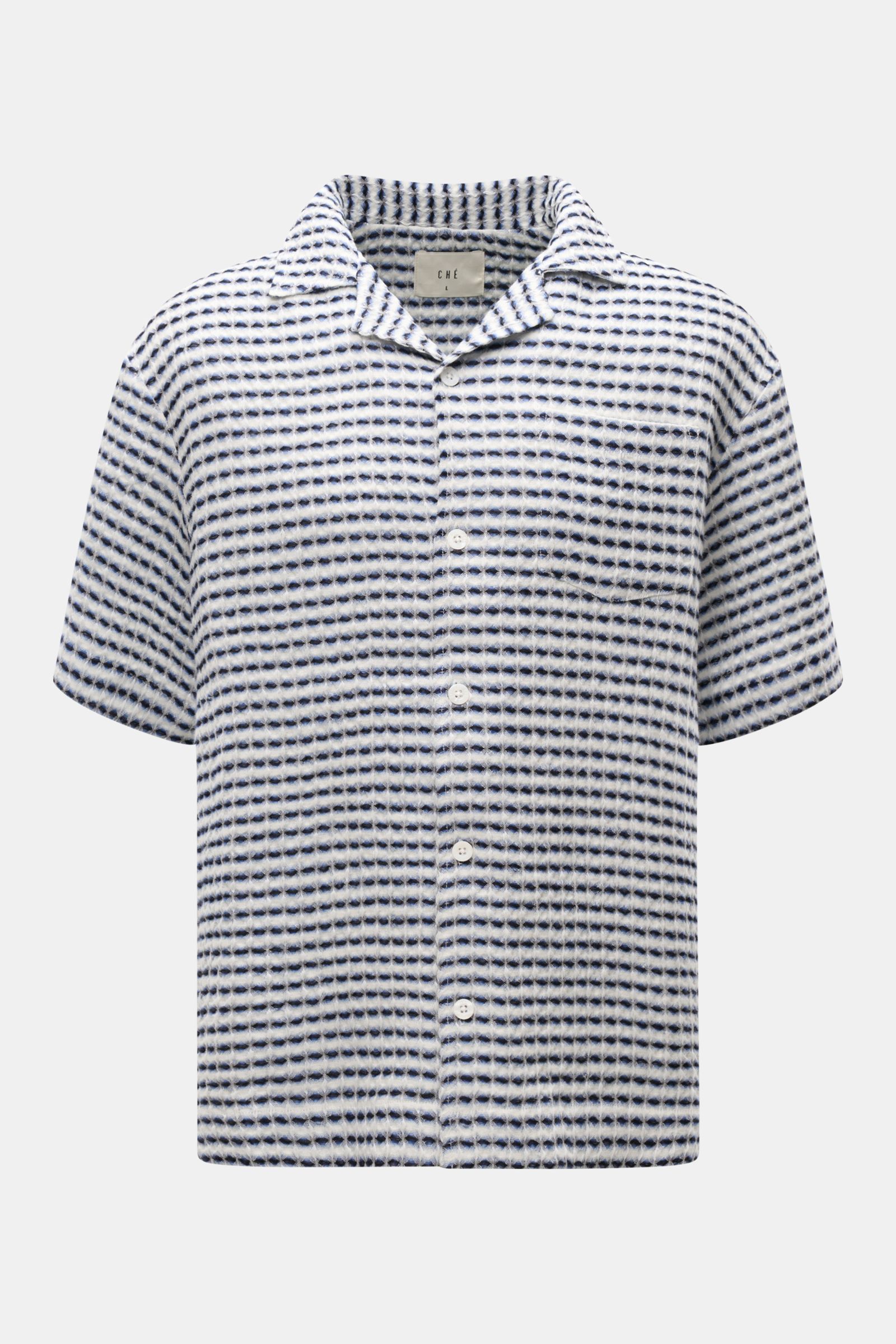 Front view of Ché Leinen-Kurzarmhemd 'Riita' Kubanischer Kragen blau/weiß gemustert, a summer linen short-sleeve shirt with Cuban collar, waffle piqué texture, chest pocket, pearl-look buttons, ribbed cuffs, oversized fit, and straight hem.  
Im Sommer