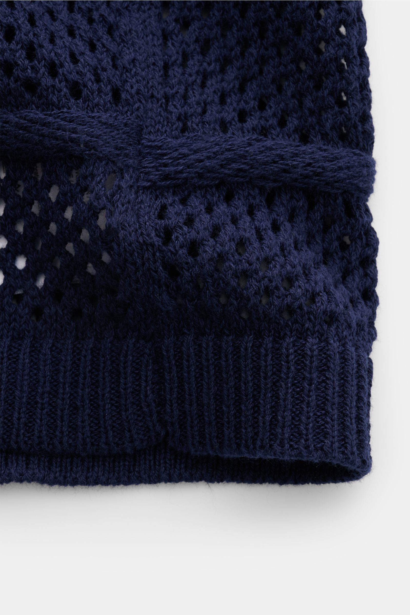 Nahaufnahme des Ché Kurzarm-Strickhemd 'Desiderio' Kubanischer Kragen navy mit grobem, luftigen Strickmuster und Rippbündchen, Detail von unten.