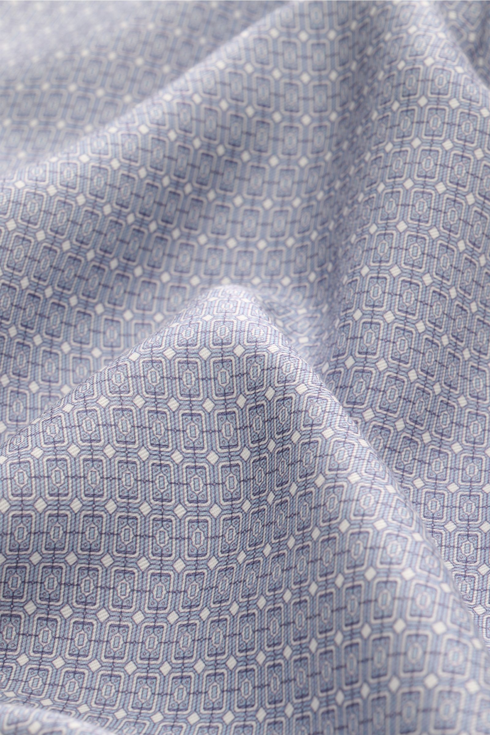 Close-up front view of fabric with ornamental print in smoke blue and off-white, highlighting the texture of Ché Kurzarmhemd 'Lucena' Kubanischer Kragen rauchblau/offwhite gemustert, a short-sleeved shirt made of pure Lyocell with smooth touch, lightweigh