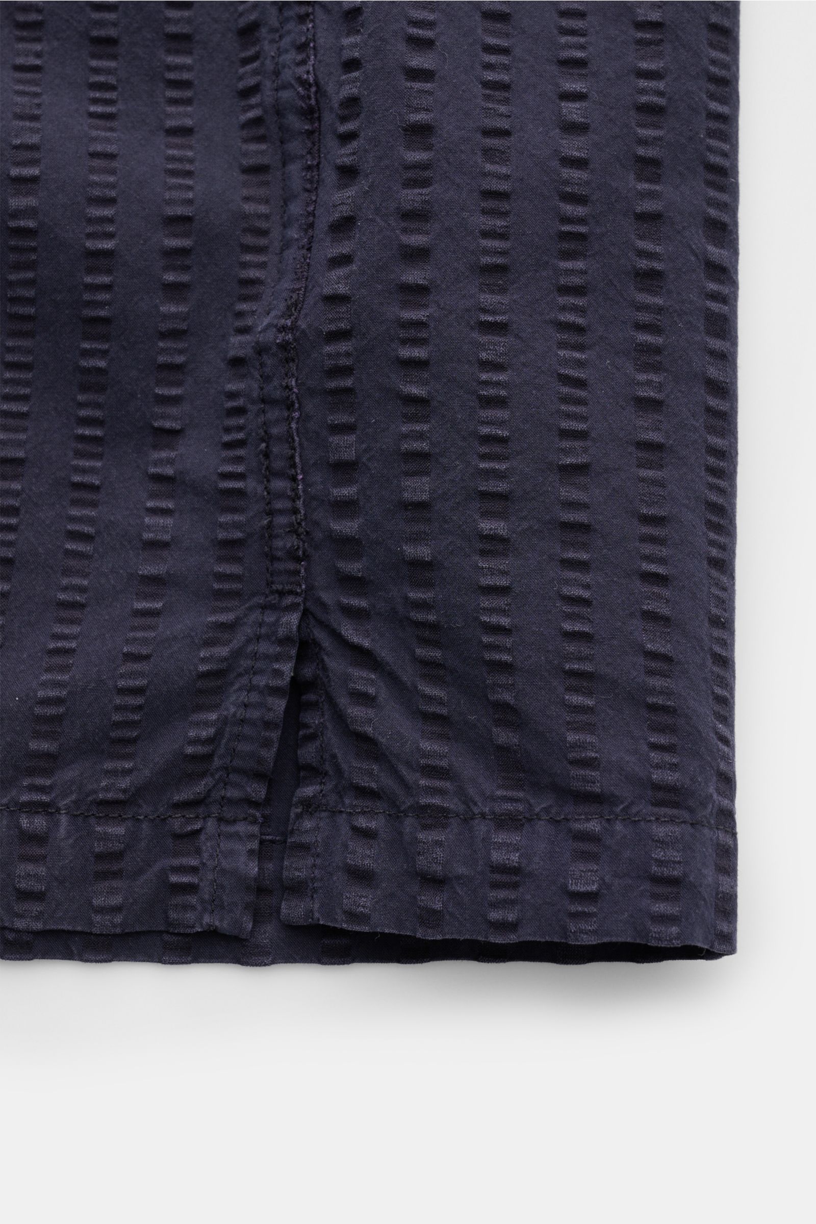 Close-up front view of the straight hem of Officine Générale Short sleeve shirt 'Eren' Cuban collar navy, showing lightweight seersucker texture and stitching.