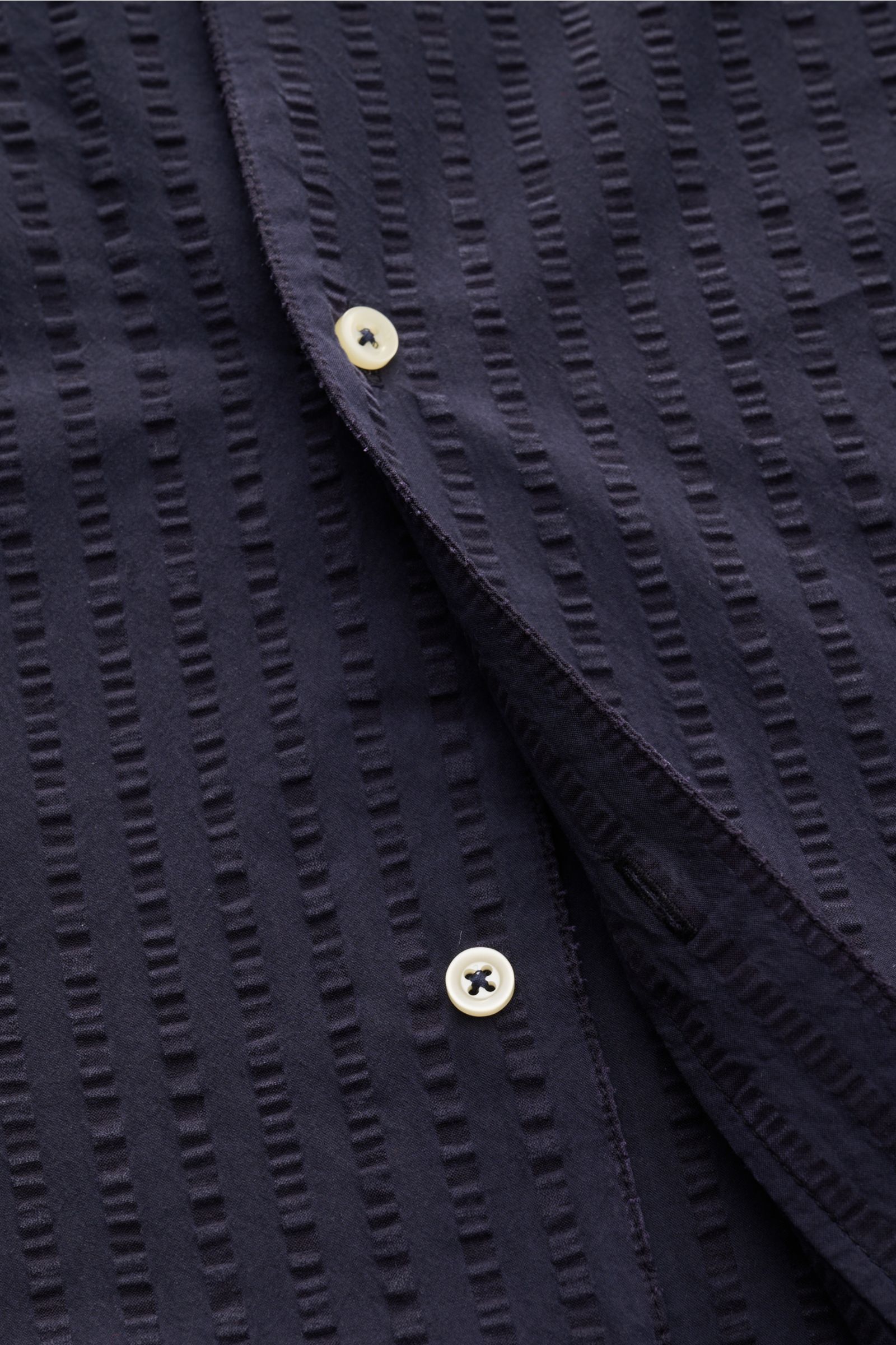 Close-up front view of Officine Générale Short sleeve shirt 'Eren' Cuban collar navy showing lightweight seersucker fabric, French button placket, textured navy stripes, and white buttons. Get a casual look for warm days: This short sleeve shirt by OFFICI
