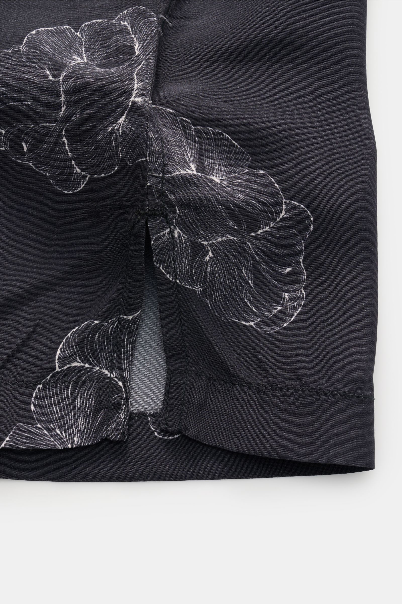 Close-up side view of the Officine Générale Short-sleeved shirt 'Eren' Cuban collar black patterned, showing side vent and floral print. Get a casual look for warm days: The short-sleeved shirt 'Eren' by OFFICINE GÉNÉRALE has a lightweight texture in pure