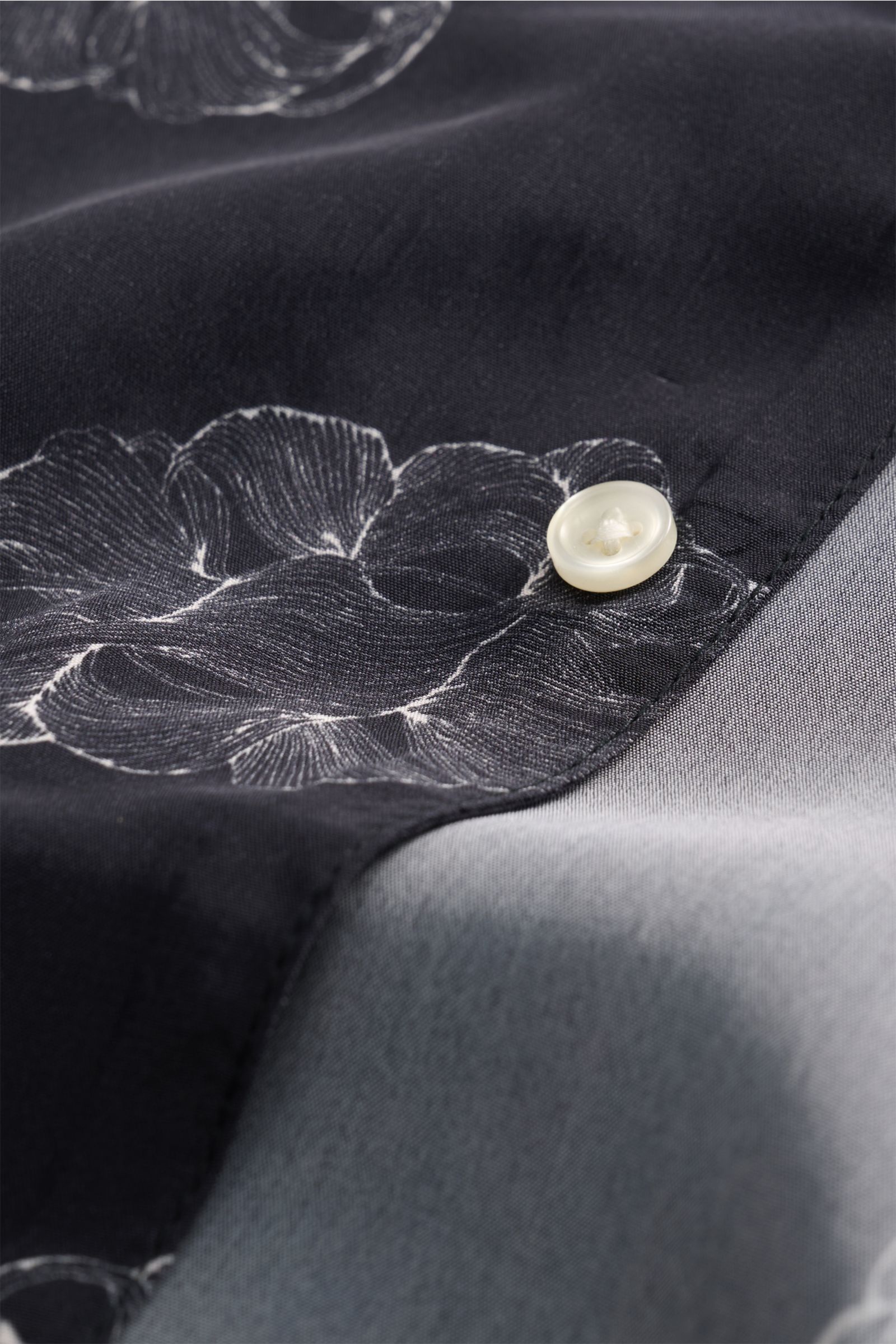 Close-up top-down view of the Officine Générale Short-sleeved shirt 'Eren' Cuban collar black patterned showing fabric texture and button detail. Get a casual look for warm days: The short-sleeved shirt 'Eren' by OFFICINE GÉNÉRALE has a lightweight textur