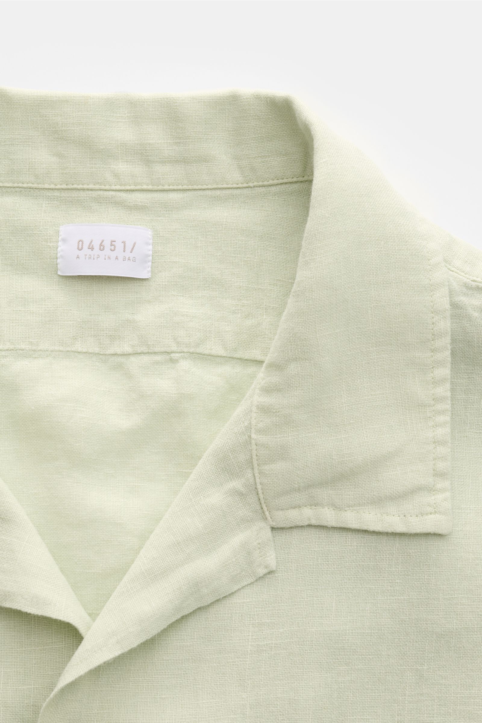 Nahaufnahme des pastellgrünen 04651/ A trip in a bag Leinen-Kurzarmhemd Kubanischer Kragen, reine Leinenstruktur, leichter Stoff, französische Knopfleiste.