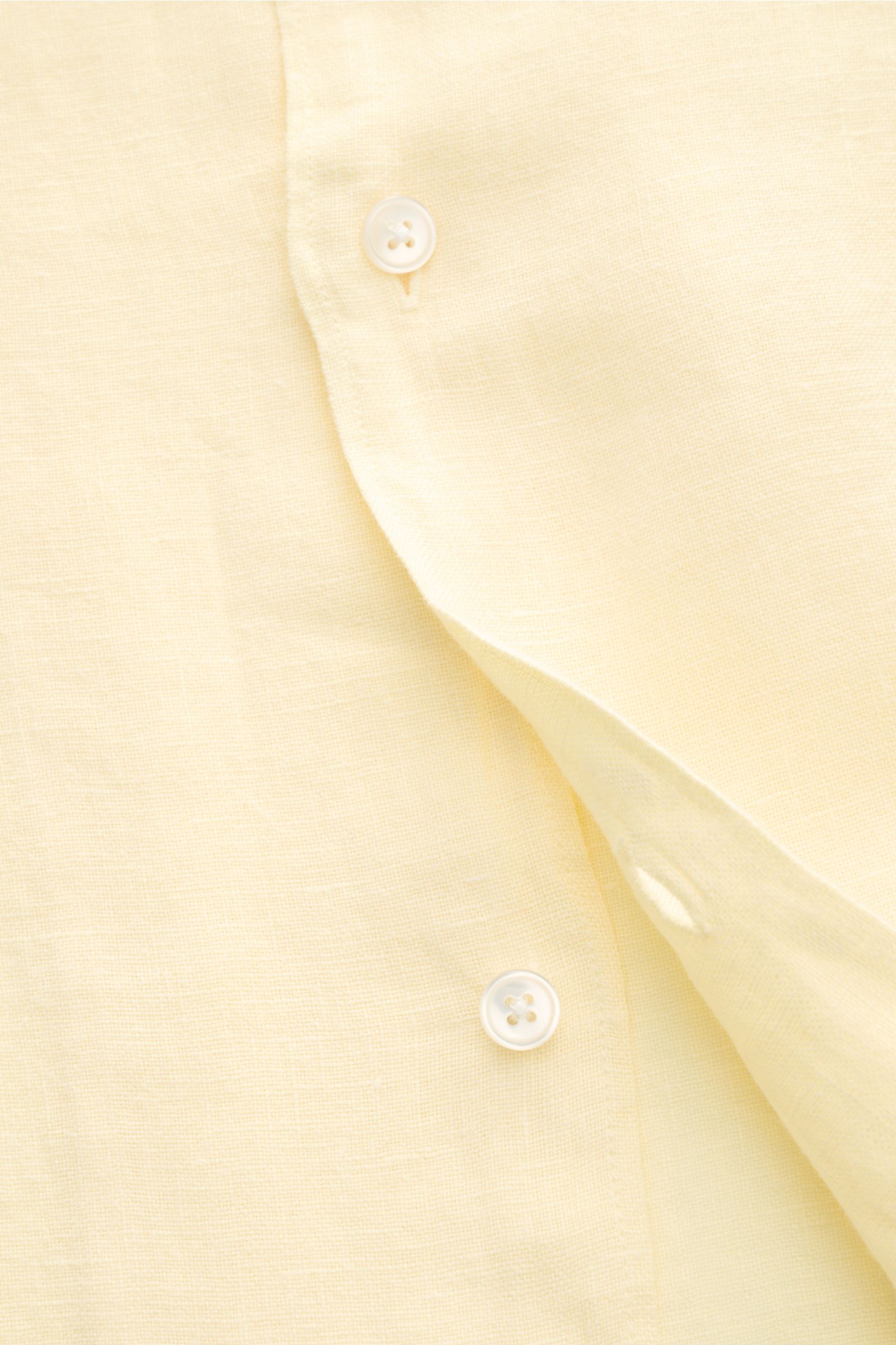 Leicht geöffnete Nahaufnahme des pastellgelben 04651/ A trip in a bag Leinen-Kurzarmhemd Kubanischer Kragen aus reinem Leinen.