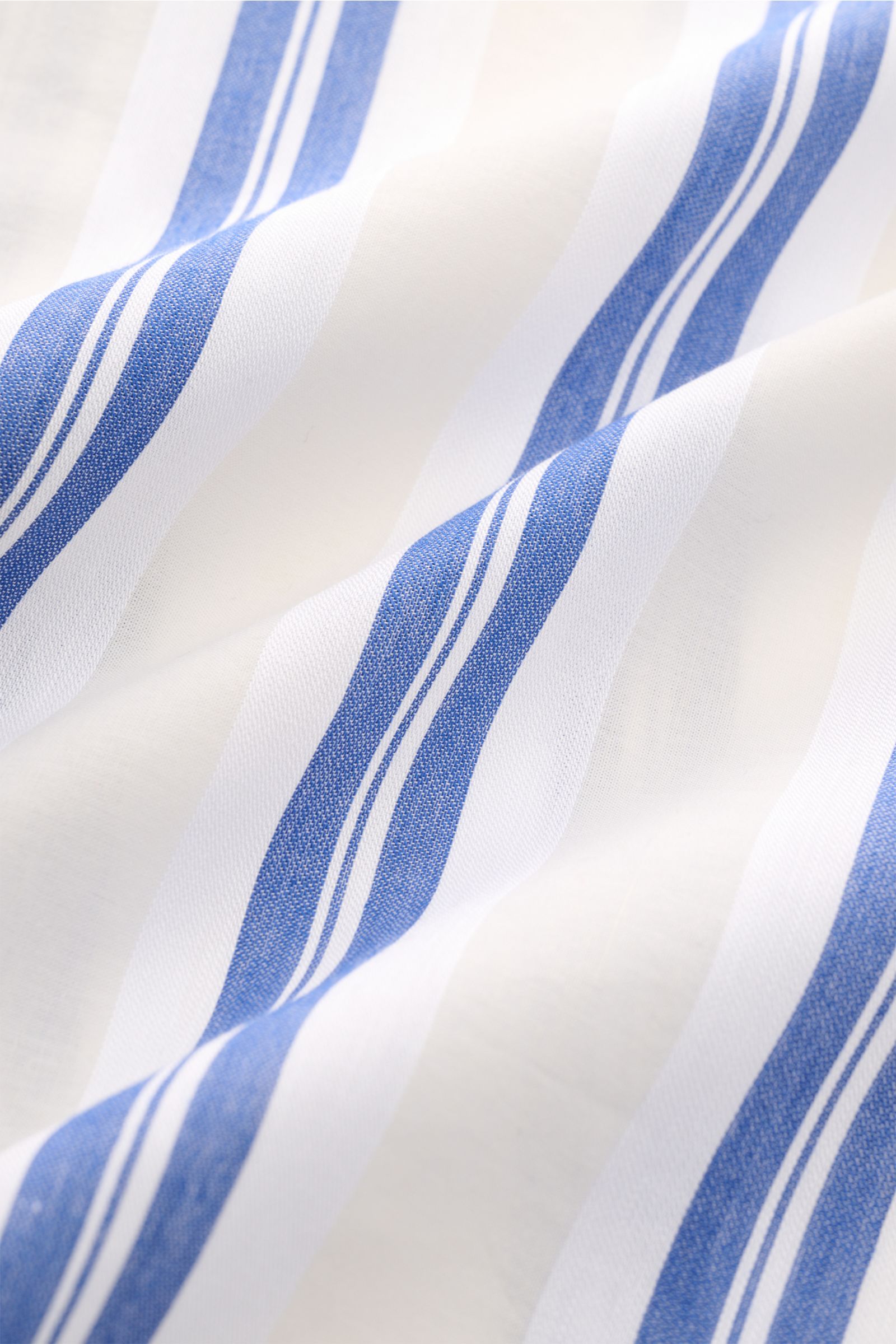 Close-up fabric texture of the 04651/ A trip in a bag Leinen-Kurzarmhemd Kubanischer Kragen pastellgelb, showing soft, wavy white linen with pastel blue stripes, highlighting the breathable, lightweight material typical of this short-sleeve shirt. 