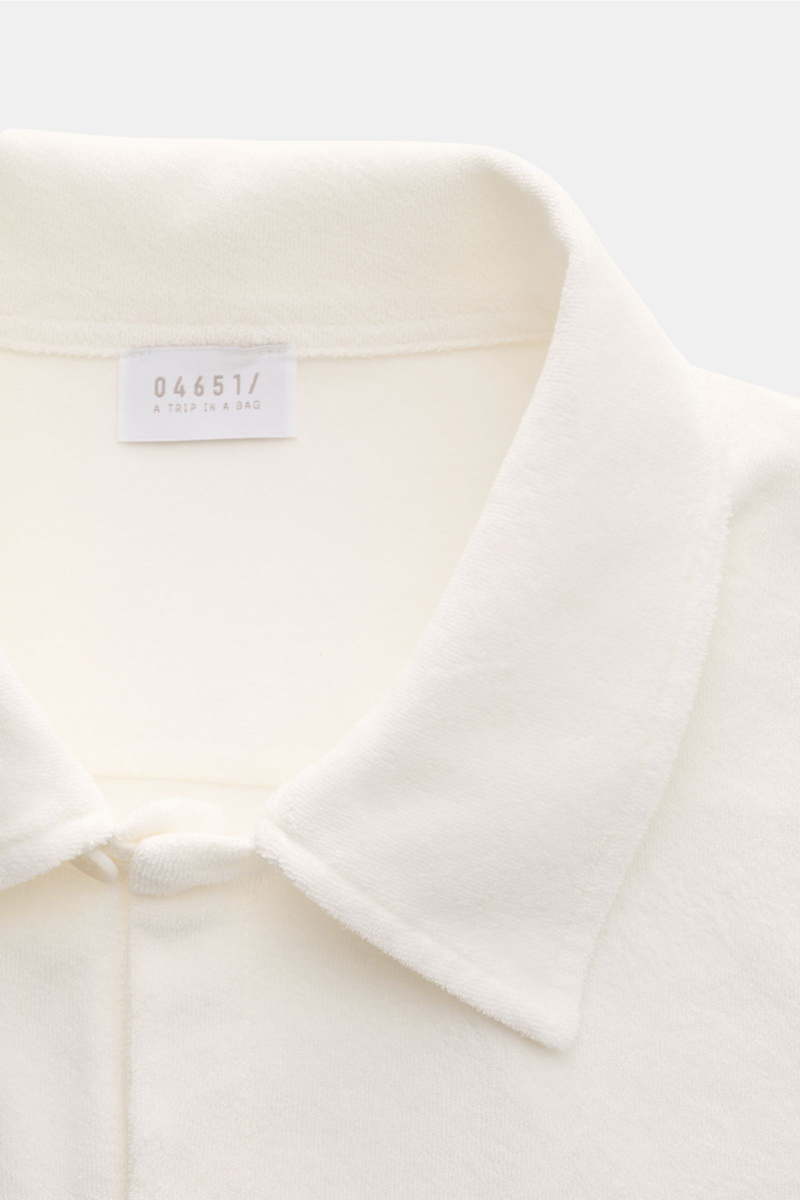 Close-up front view of the 04651/ A trip in a bag Frottee-Kurzarmhemd 'Terry Cuba' offwhite showing its variable Cuban collar and soft cotton terry fabric texture. Urlaubsgefühl zum Anziehen: Das Kurzarmhemd 'Terry Cuba' von 04651/ A TRIP IN A BAG aus ang