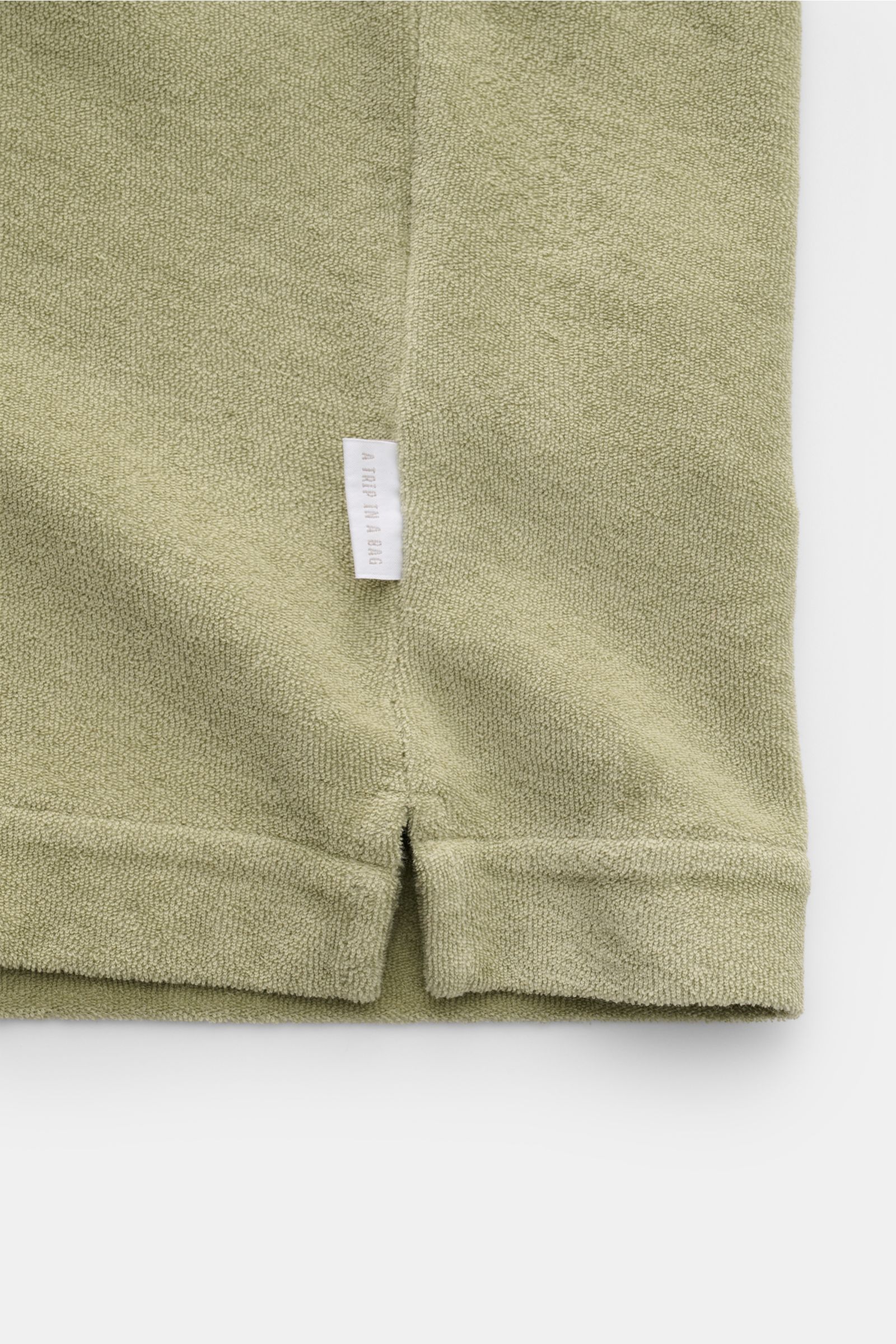 04651/ A trip in a bag Frottee-Kurzarmhemd 'Terry Cuba' salbei Detailaufnahme der kurzen Saumschlitze und Weblabel aus Baumwoll-Frottee.