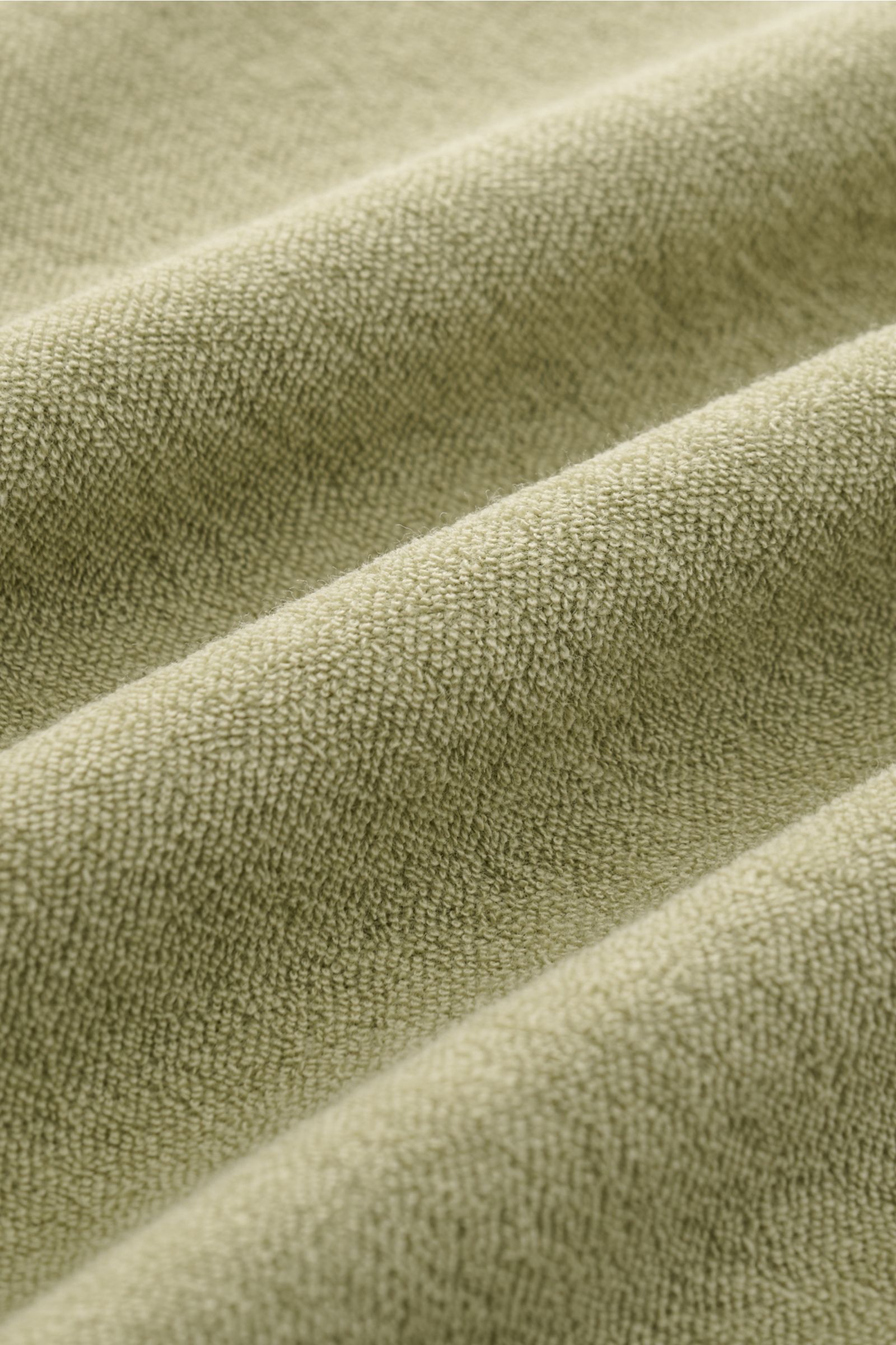 Nahaufnahme des angenehmen Baumwoll-Frottees des 04651/ A trip in a bag Frottee-Kurzarmhemd 'Terry Cuba' salbei mit weichem Griff und Textur.