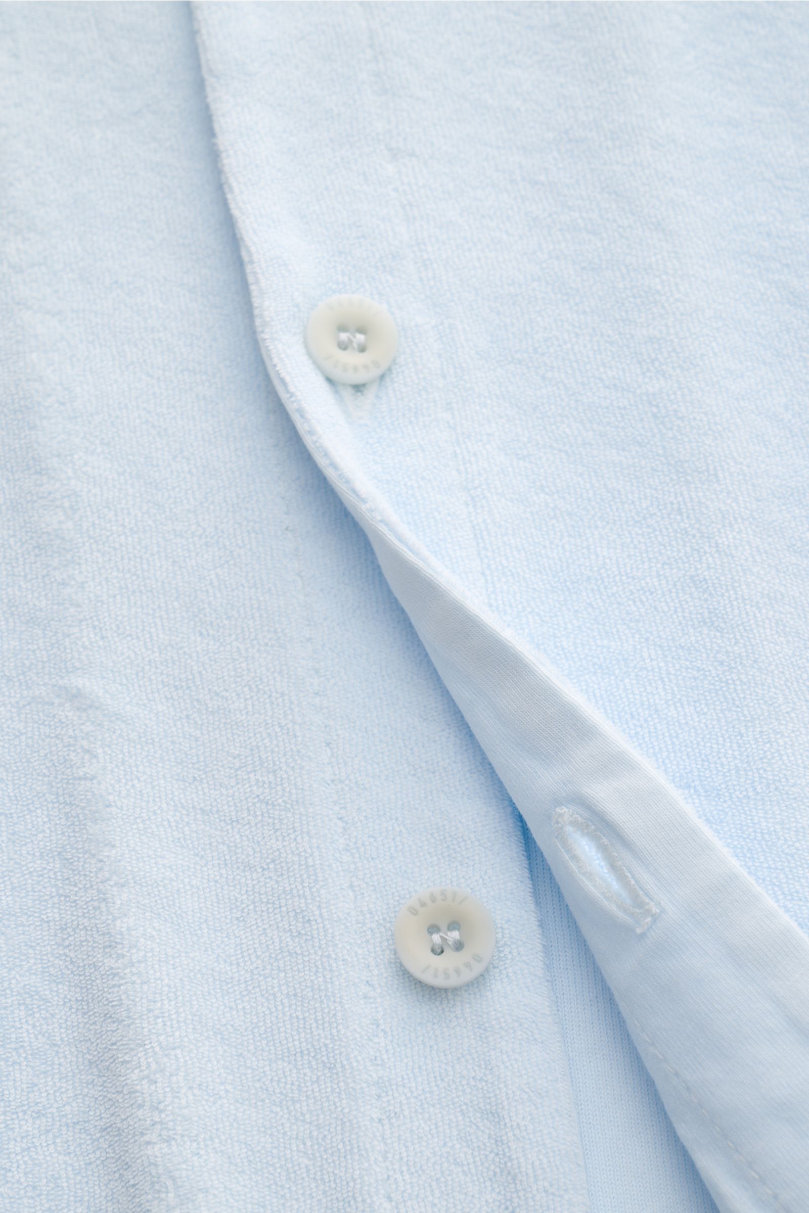 04651/ A trip in a bag Frottee-Kurzarmhemd 'Terry Cuba' pastellblau aus Baumwoll-Frottee in Nahaufnahme von vorne mit sichtbaren Knöpfen und Saumschlitzen.