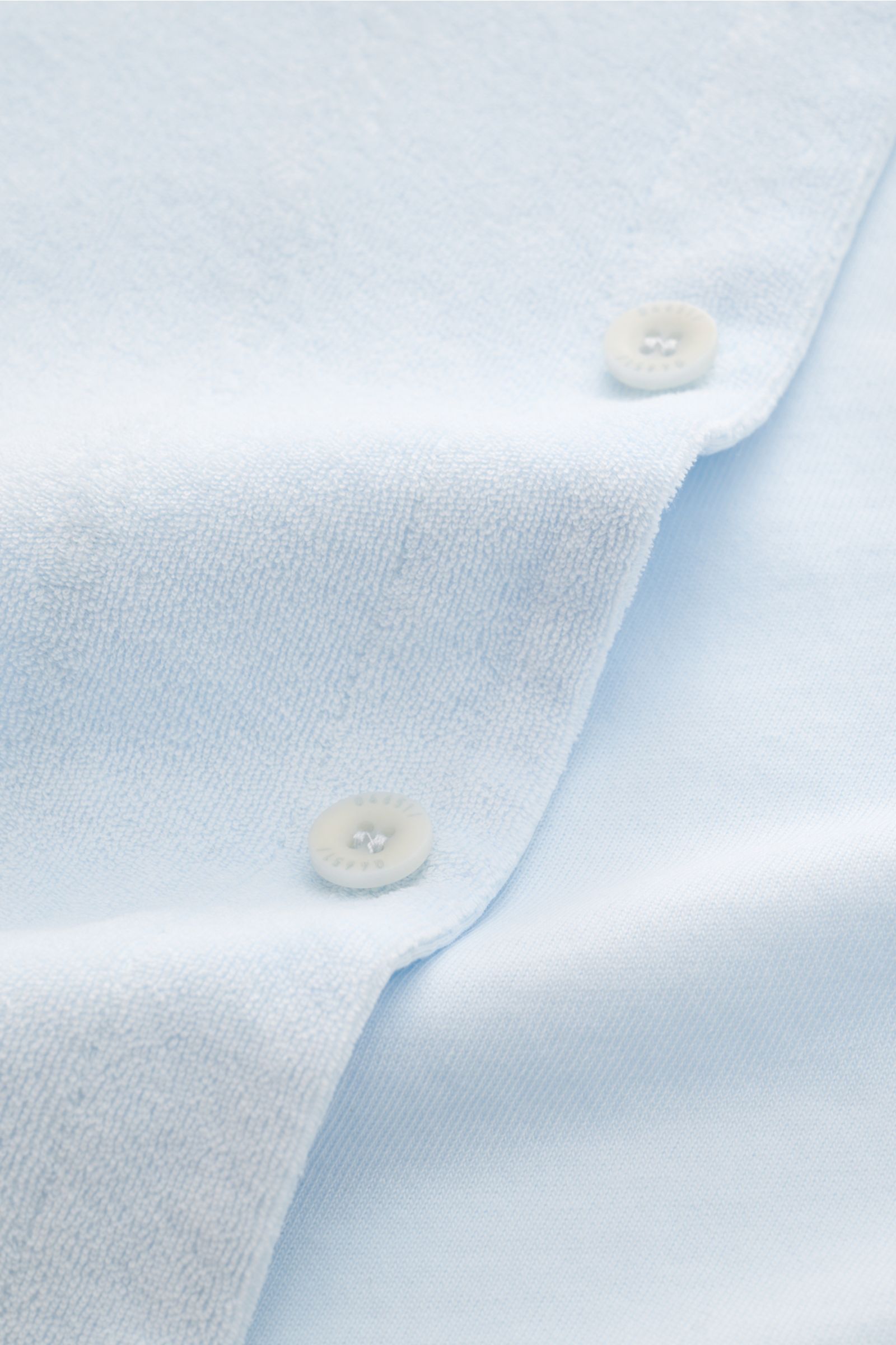 Close-up front view of 04651/ A trip in a bag Frottee-Kurzarmhemd 'Terry Cuba' pastellblau showing soft cotton terry fabric and white buttons. Urlaubsgefühl zum Anziehen: Das Kurzarmhemd 'Terry Cuba' von 04651/ A TRIP IN A BAG aus angenehmem Baumwoll-Frot