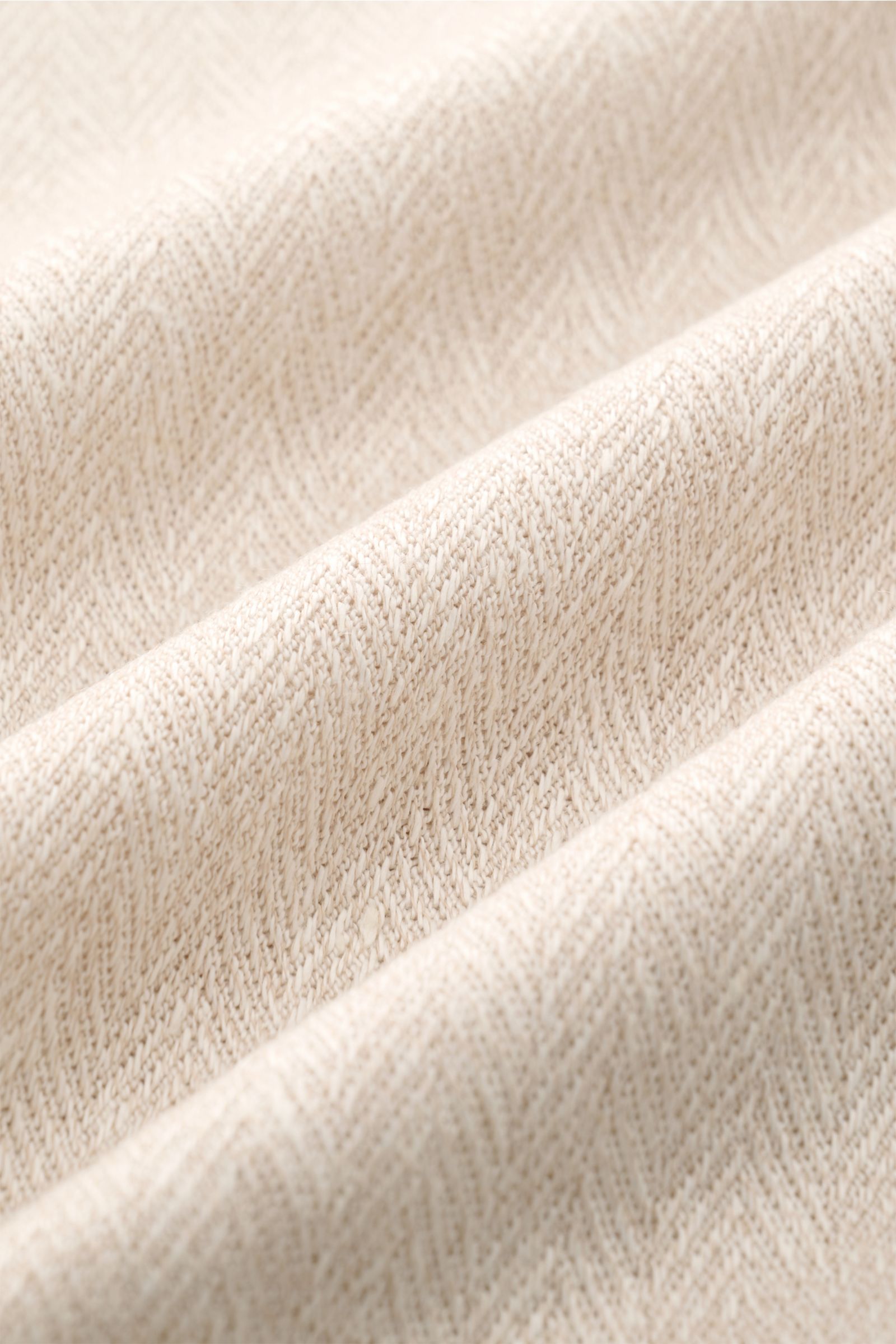 Close-up front view of the beige meliert fabric of the Brunello Cucinelli Kurzarm-Strickhemd, showcasing its fine herringbone knit pattern and soft texture. Elegantes Highlight in der Frühlings- und Sommersaison: Das luxuriöse Strickhemd von BRUNELLO CUCI