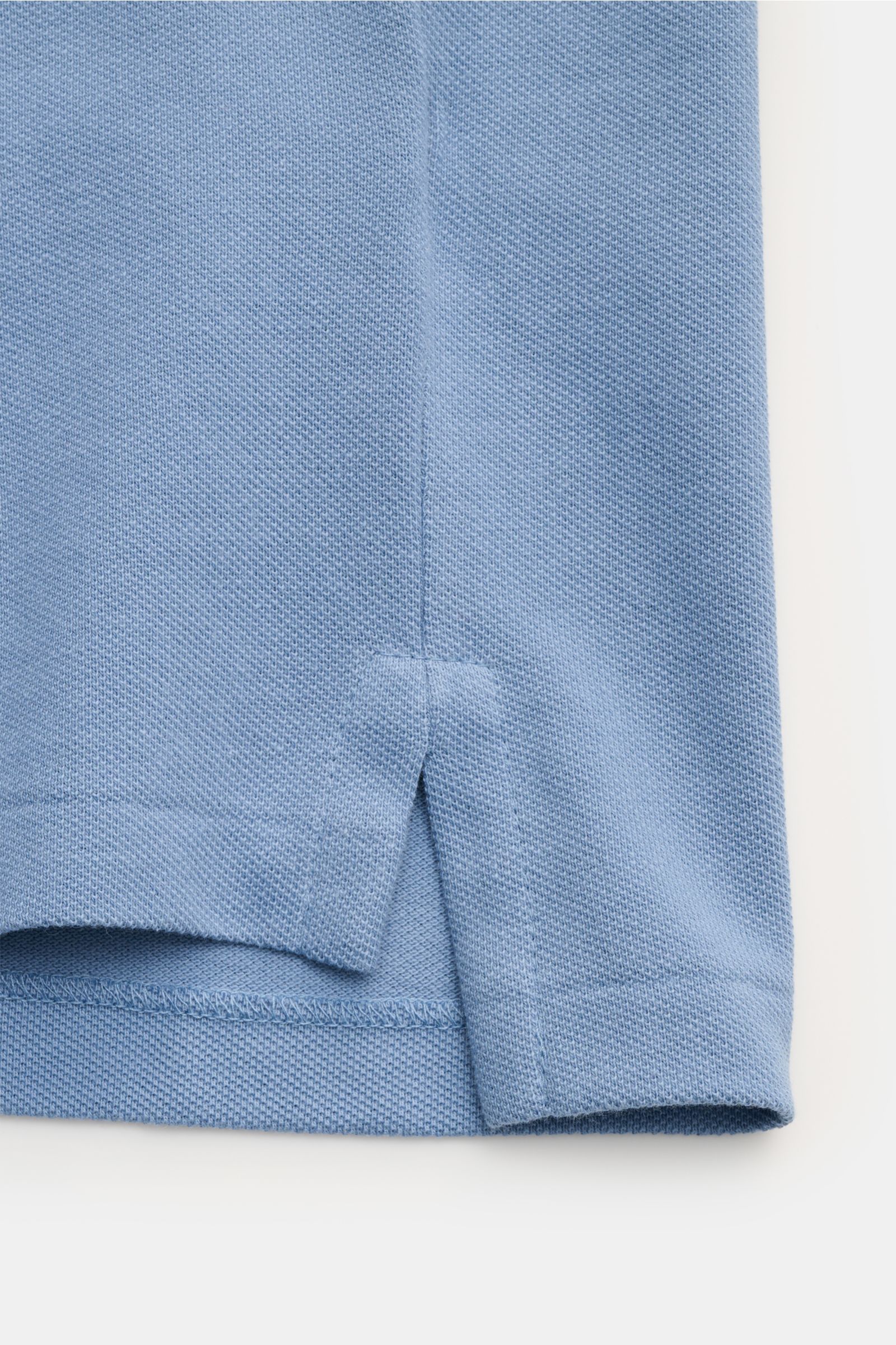 Close-up of the hem and side slit of the Polo Ralph Lauren Poloshirt hellblau, showing fine piqué cotton texture from a side angle. Seit 1972 der Klassiker unter den Poloshirts: Das ikonisches Piqué-Modell aus reiner Baumwolle mit dem berühmten Polorei
