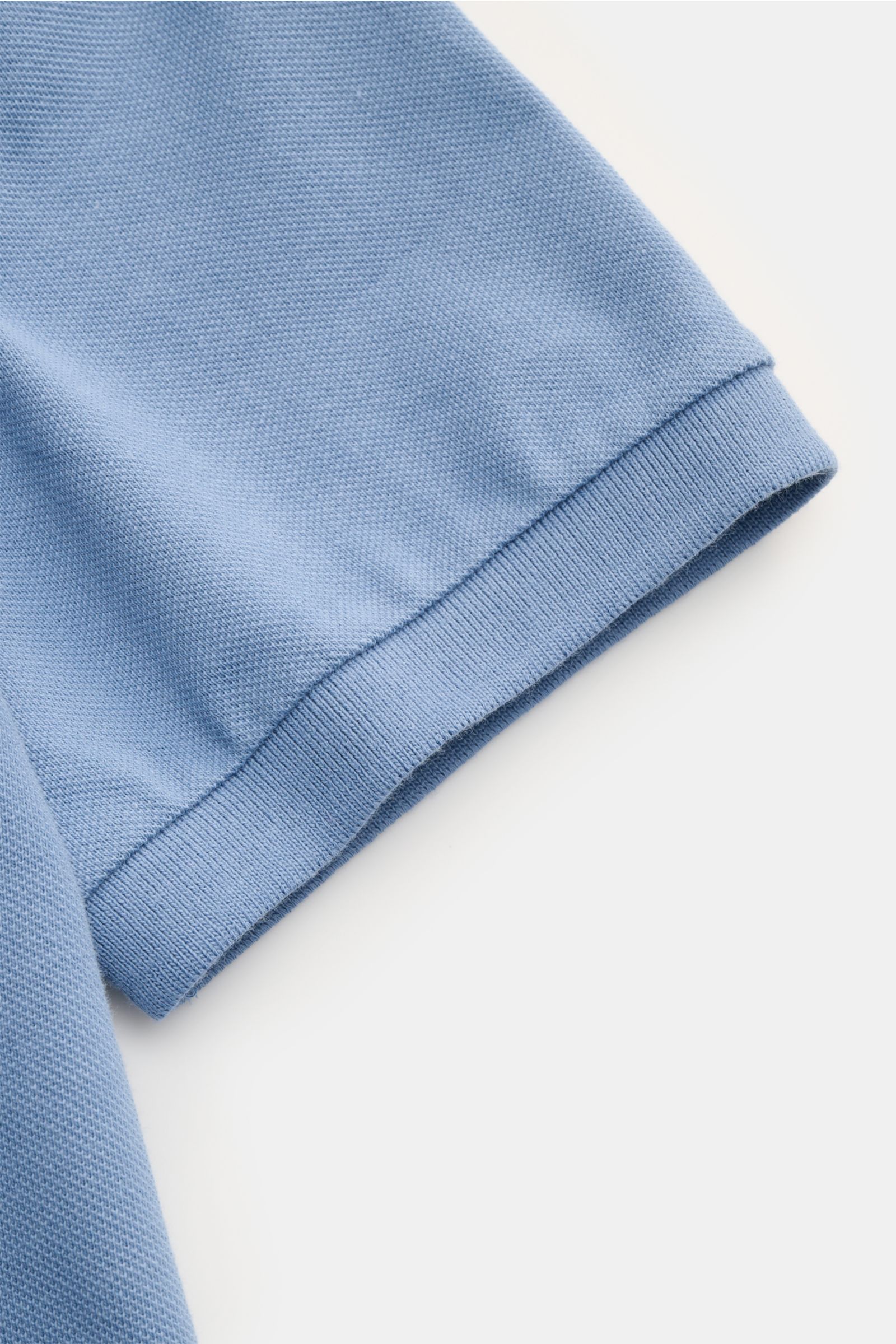 Close-up side view of Polo Ralph Lauren Poloshirt hellblau sleeve showing fine piqué cotton texture and elastic cuff. Seit 1972 der Klassiker unter den Poloshirts: Das ikonisches Piqué-Modell aus reiner Baumwolle mit dem berühmten Poloreiter-Stitching 