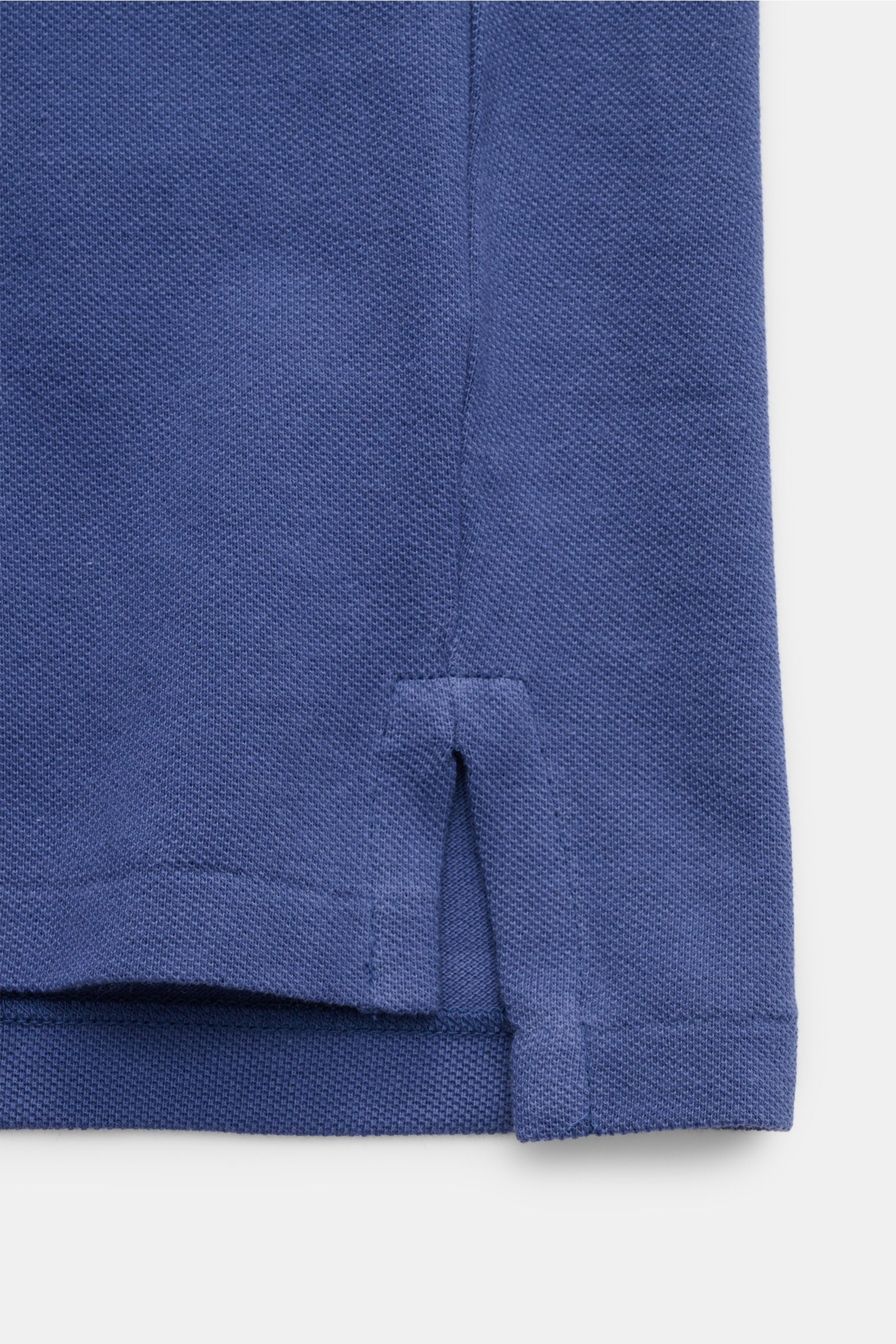 Close-up view of the lower hem and side slit of a Polo Ralph Lauren Poloshirt graublau, featuring a fine Piqué structure and cotton jersey fabric. Seit 1972 der Klassiker unter den Poloshirts: Das ikonisches Piqué-Modell aus reiner Baumwolle mit dem be