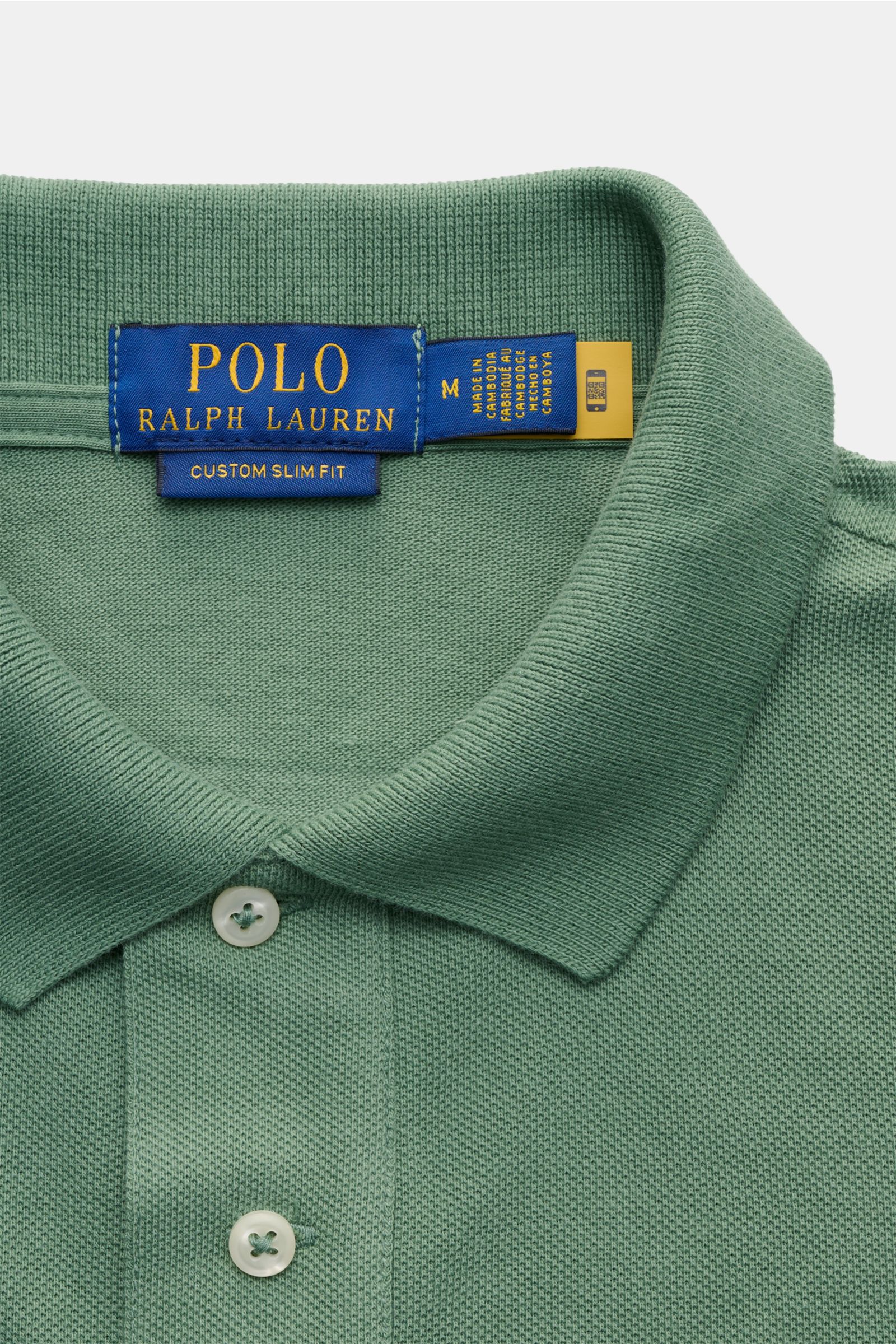 Polo Ralph Lauren Poloshirt grün in Slim Fit, grüne Piqué-Struktur, Polokragen, Zwei-Knopf-Leiste, Detailaufnahme von oben.