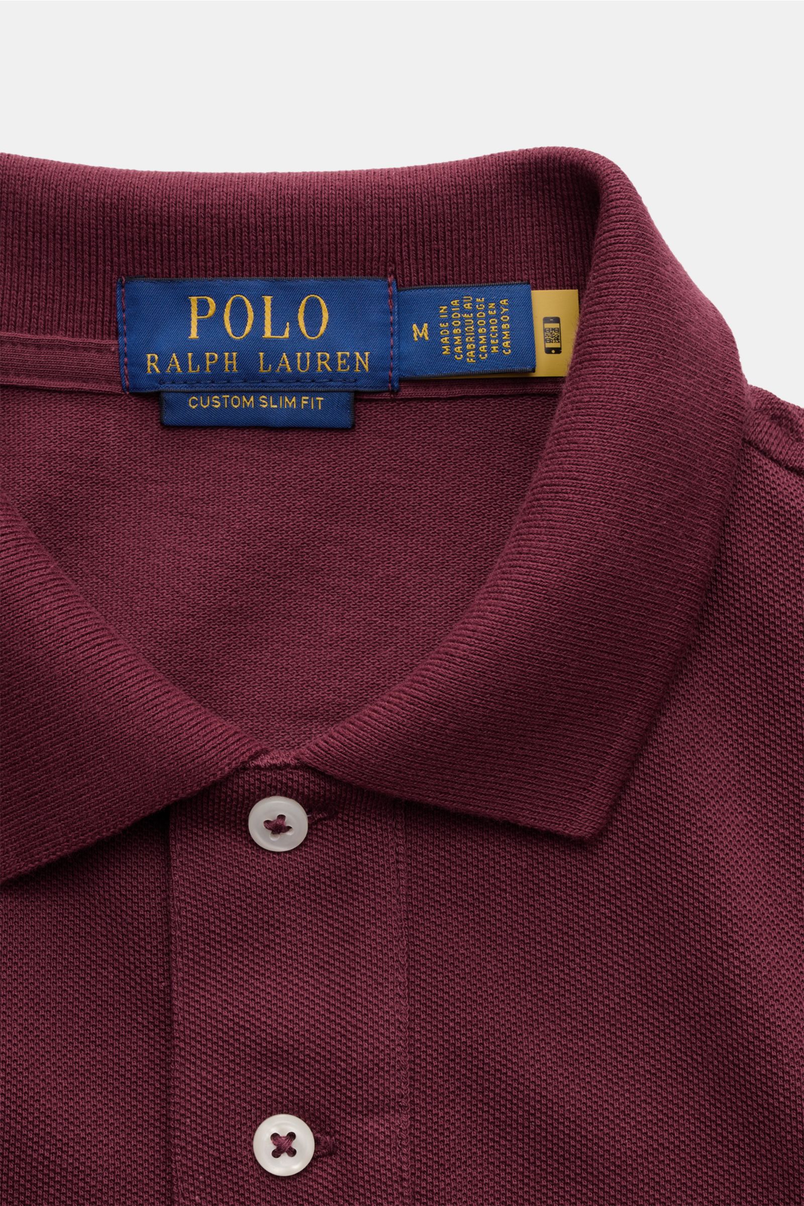 Polo Ralph Lauren Poloshirt bordeaux in Nahaufnahme von oben, Slim Fit aus reiner Baumwolle mit feiner Piqué-Struktur, Polokragen und Zwei-Knopf-Leiste. Seit 1972 ein Klassiker mit ikonischem Poloreiter-Stitching.
