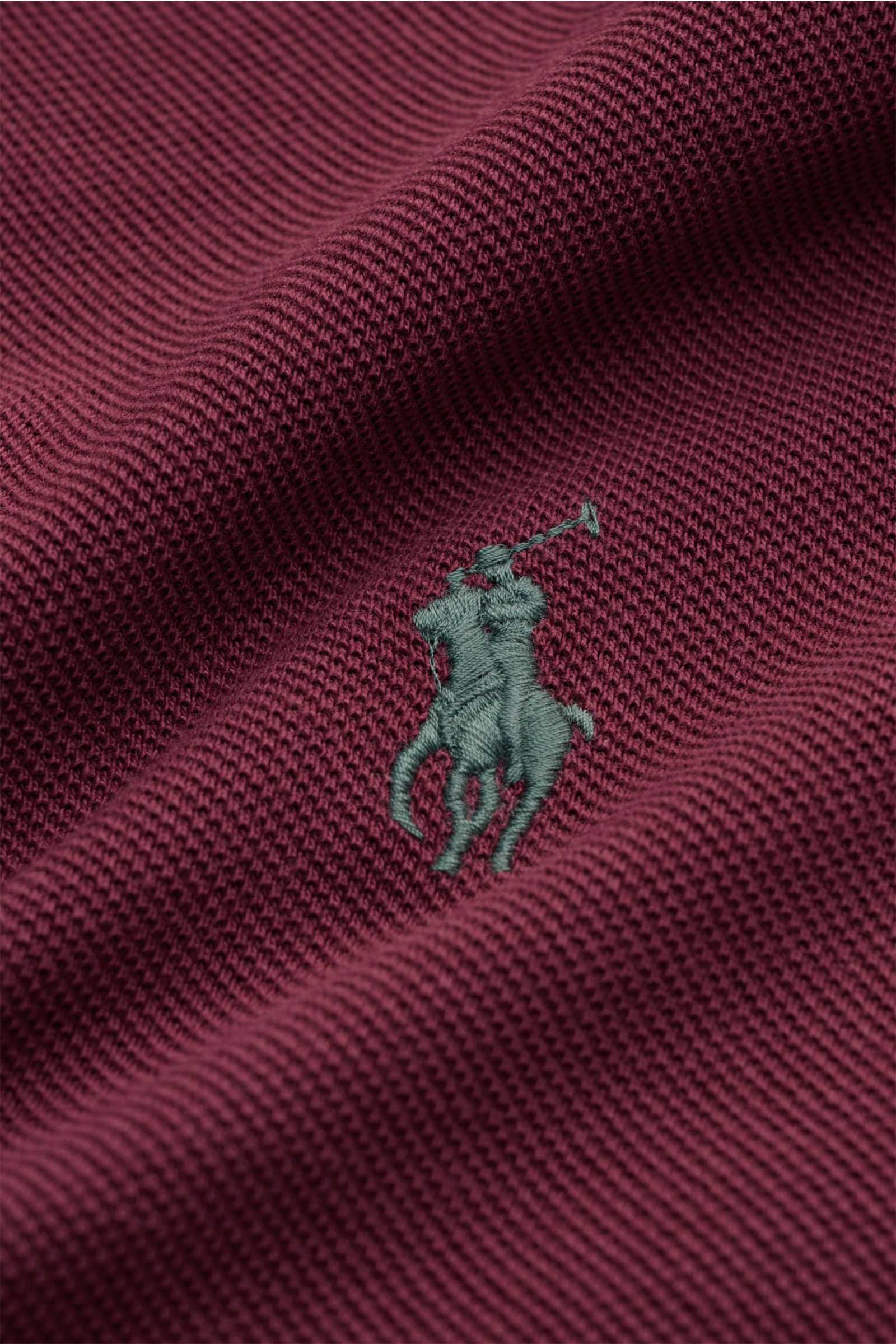 Nahaufnahme des bordeauxfarbenen Polo Ralph Lauren Poloshirts mit feiner Piqué-Struktur und grünem Poloreiter-Stitching in Slim Fit.