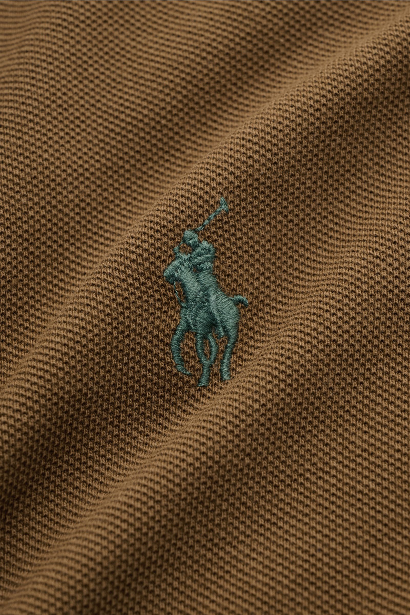 Nahaufnahme des braunen Polo Ralph Lauren Poloshirts mit feiner Piqué-Struktur und grünem Poloreiter-Stitching auf der Brust.