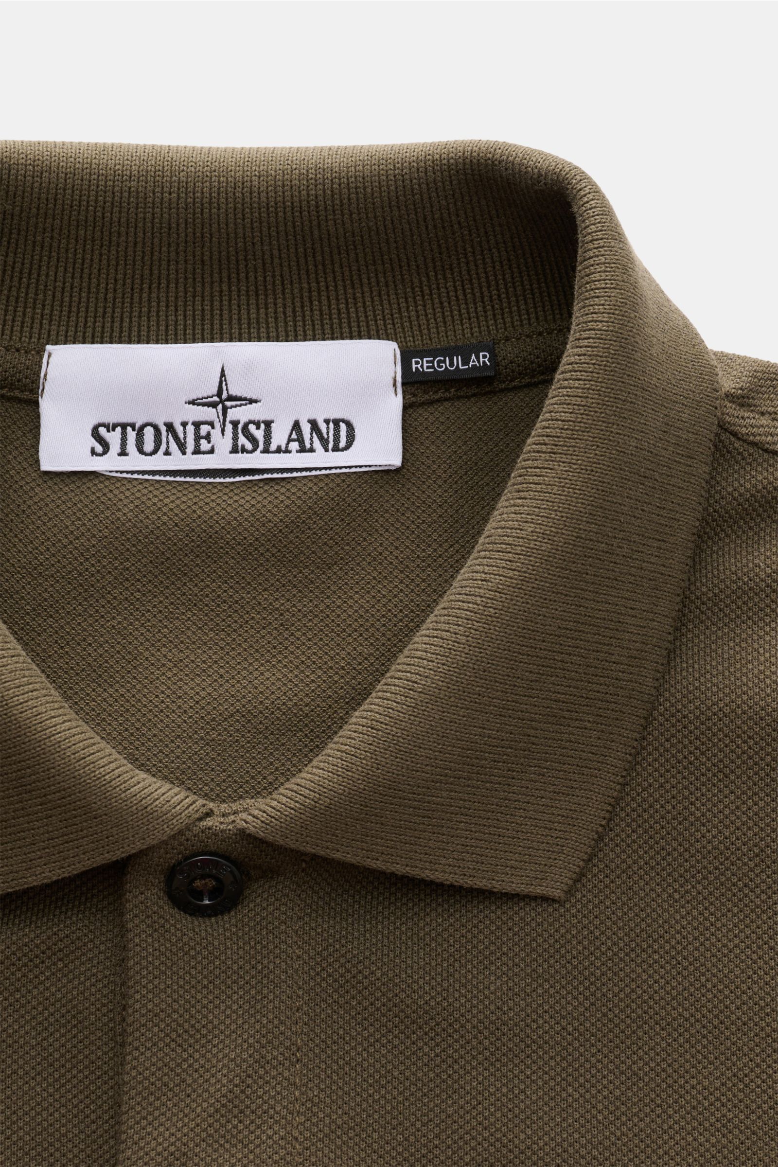Nahaufnahme des Stone Island Poloshirts oliv aus Baumwoll-Piqué, slim fit, mit typischem Polokragen, glatter Knopfleiste und Weblabel.