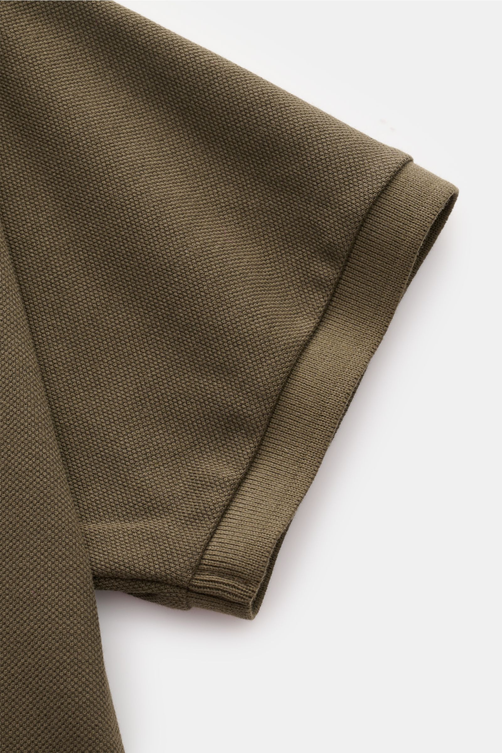 Stone Island Poloshirt oliv, Detailaufnahme des kurzärmligen Baumwoll-Piqué-Stoffes, strukturierter Griff, flexible Ärmelbündchen, seitliche Saumschlitze.