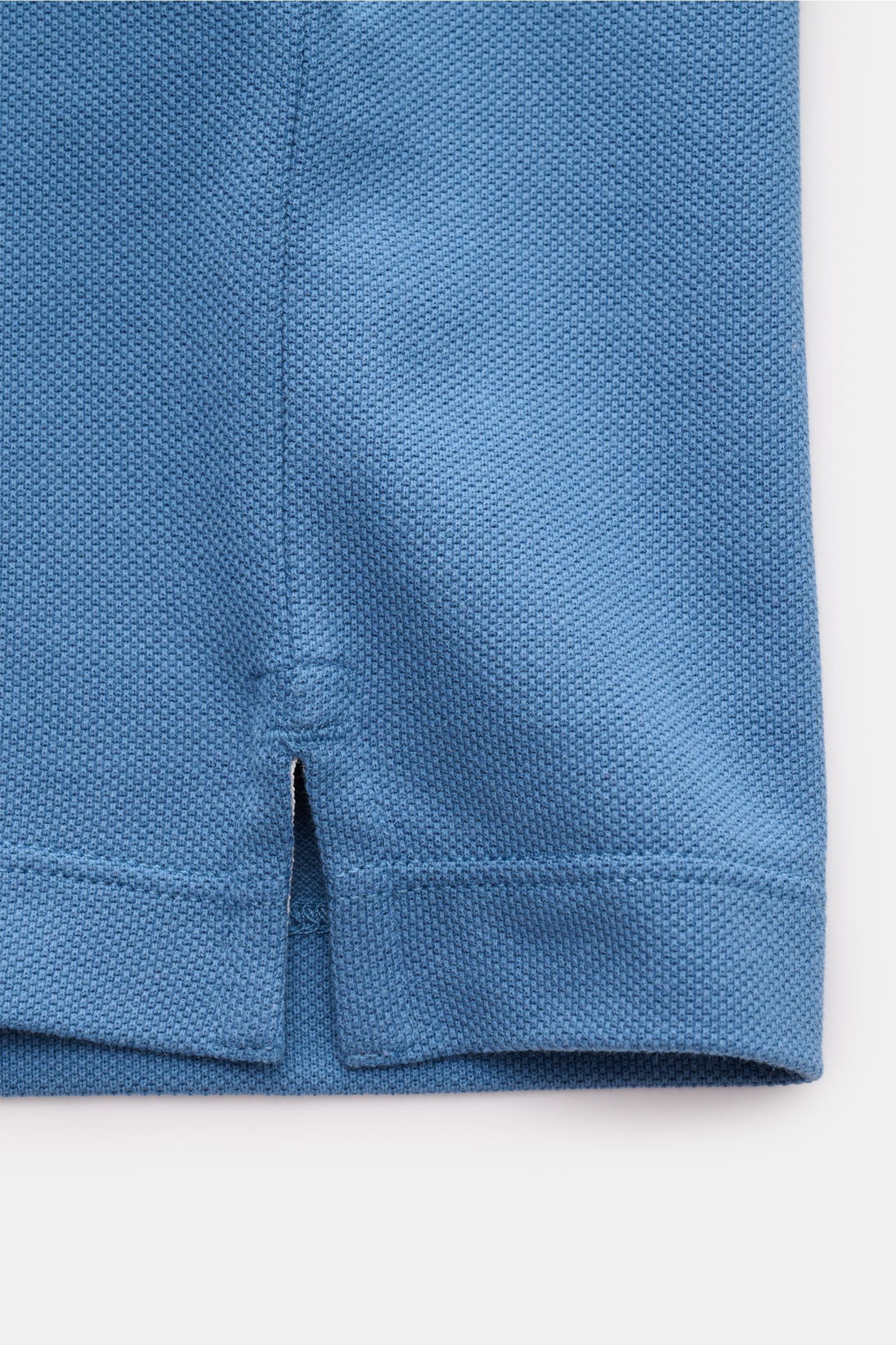 Stone Island Poloshirt graublau aus Baumwoll-Piqué, Slim Fit, mit seitlichem Saumschlitz, flexiblem Ärmelbündchen, Polokragen, glatter Knopfleiste, Detailaufnahme von unten.