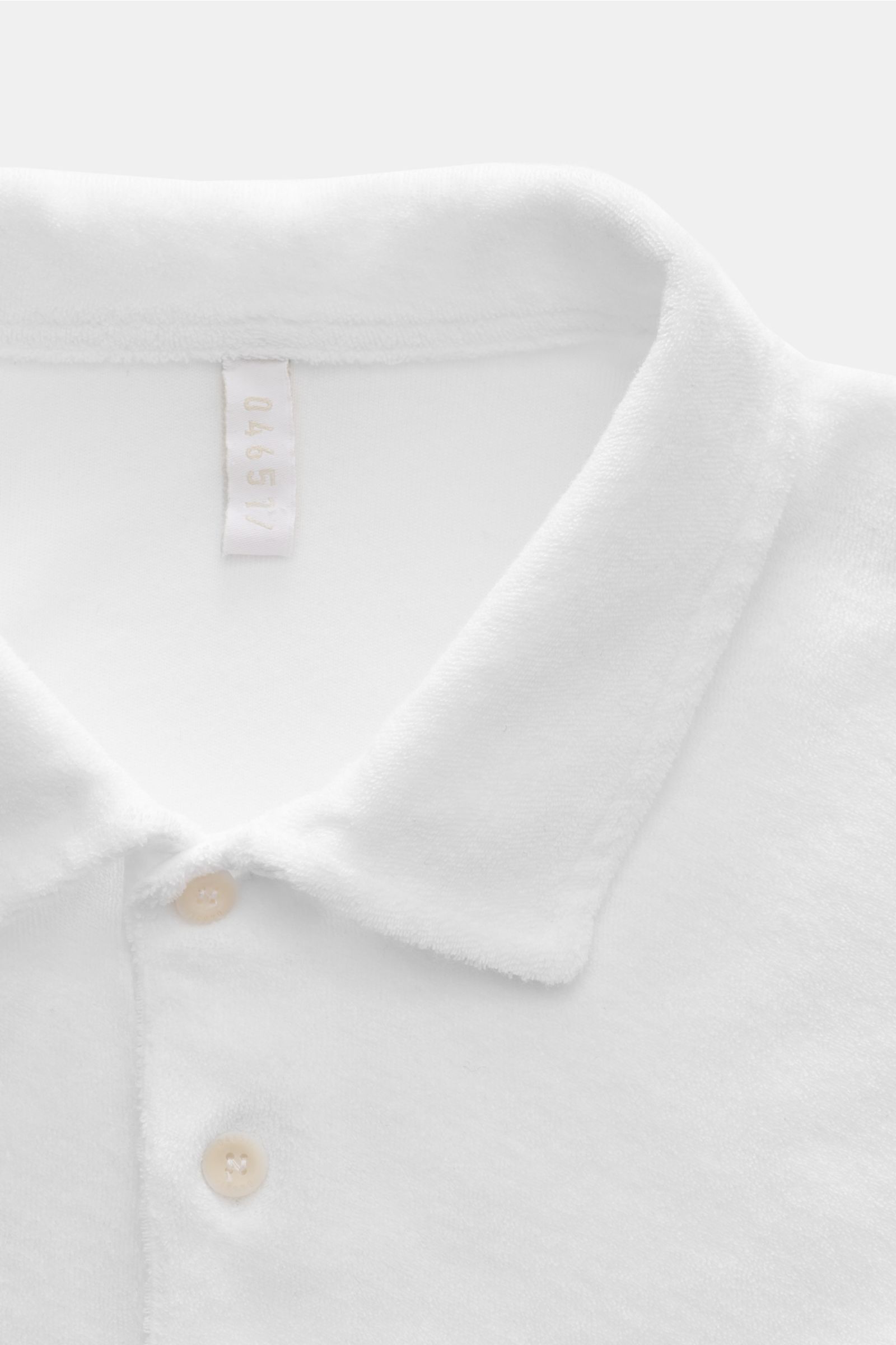 Nahaufnahme von weißem 04651/ A trip in a bag Frottee-Poloshirt 'Terry Polo' mit Regular Fit, Polokragen und glatter Knopfleiste aus reiner Baumwolle.