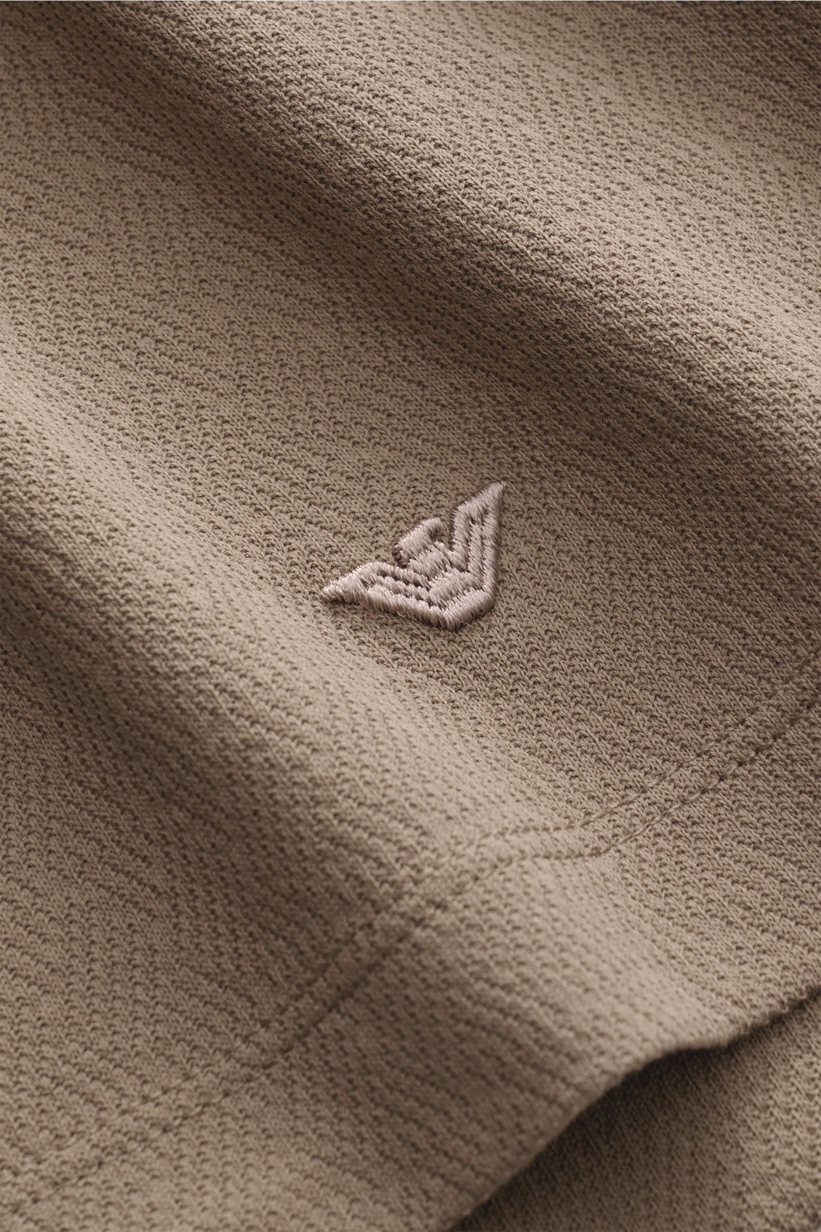 Emporio Armani Poloshirt taupe in Slim Fit, Detailaufnahme der feinen Jersey-Strukturoptik aus reiner Baumwolle mit Logo-Stickerei.