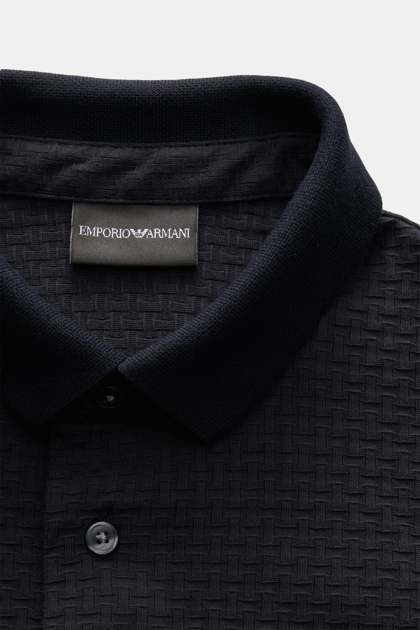 Emporio Armani Poloshirt navy in Slim Fit, aus strukturierter Baumwolle, mit Polokragen, Drei-Knopf-Leiste, geradem Saum, nah fotografiert.