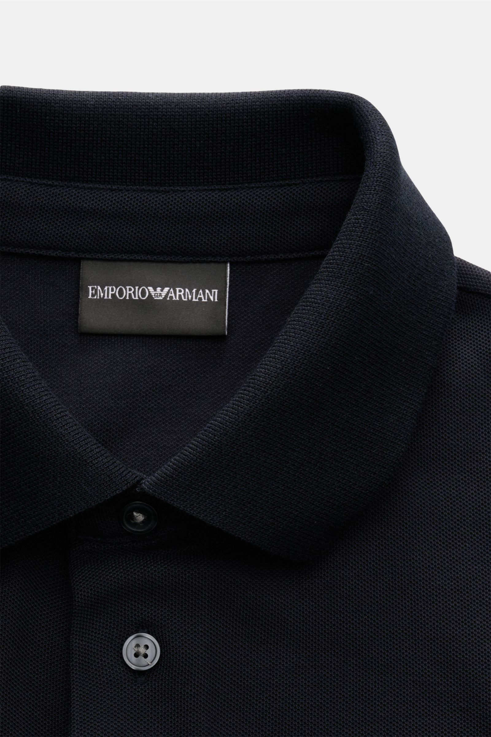 Close-up front view of the Emporio Armani Polo shirt navy showing the classic collar, two buttons, and label stitching on the chest. A versatile classic for sporty looks: This polo shirt by EMPORIO ARMANI has a timeless, casual design. Piqué jersey made o