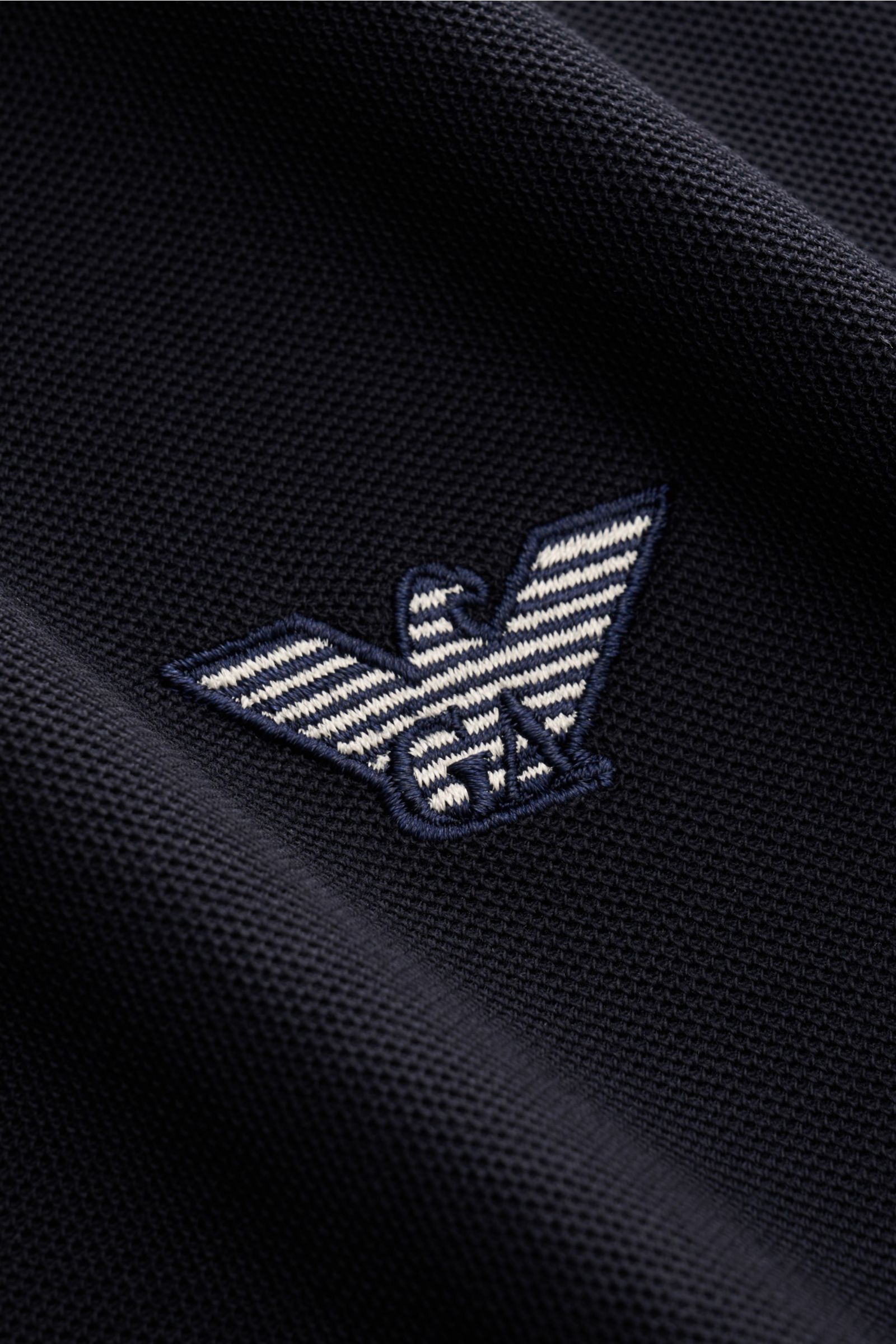 Close-up view of the chest area of the Emporio Armani Polo shirt navy, showing the label stitching on piqué jersey fabric. A versatile classic for sporty looks: This polo shirt by EMPORIO ARMANI has a timeless, casual design. Piqué jersey made of pure cot