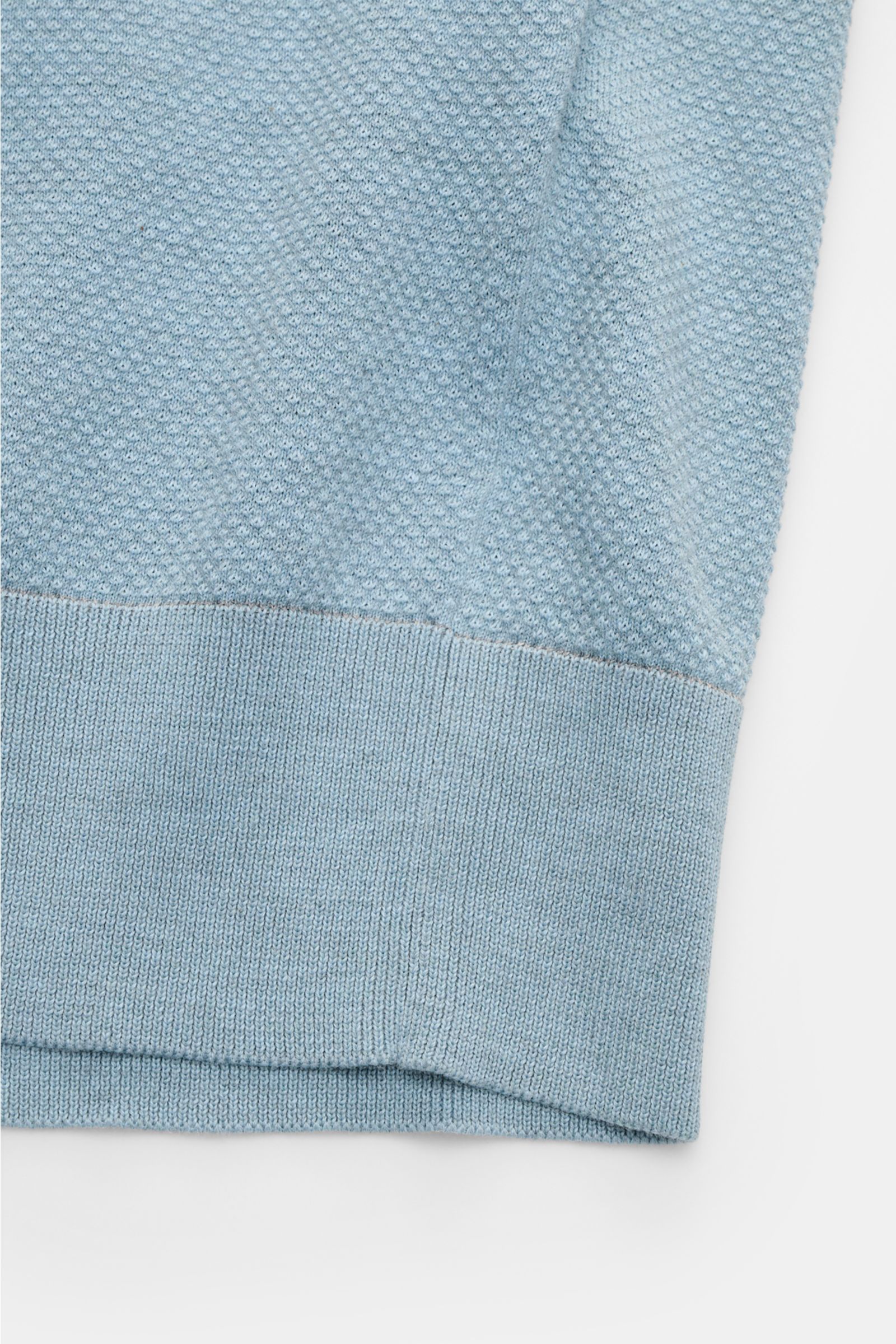 Close-up front view of the Brioni Kurzarm-Strickpolo rauchblau showing its airy, lightweight cotton knit with slim fit, ribbed cuffs, and textured fabric. Genießen Sie den Sommer stilvoll mit dem luftig gestrickten Polo von BRIONI - gefertigt aus reiner B