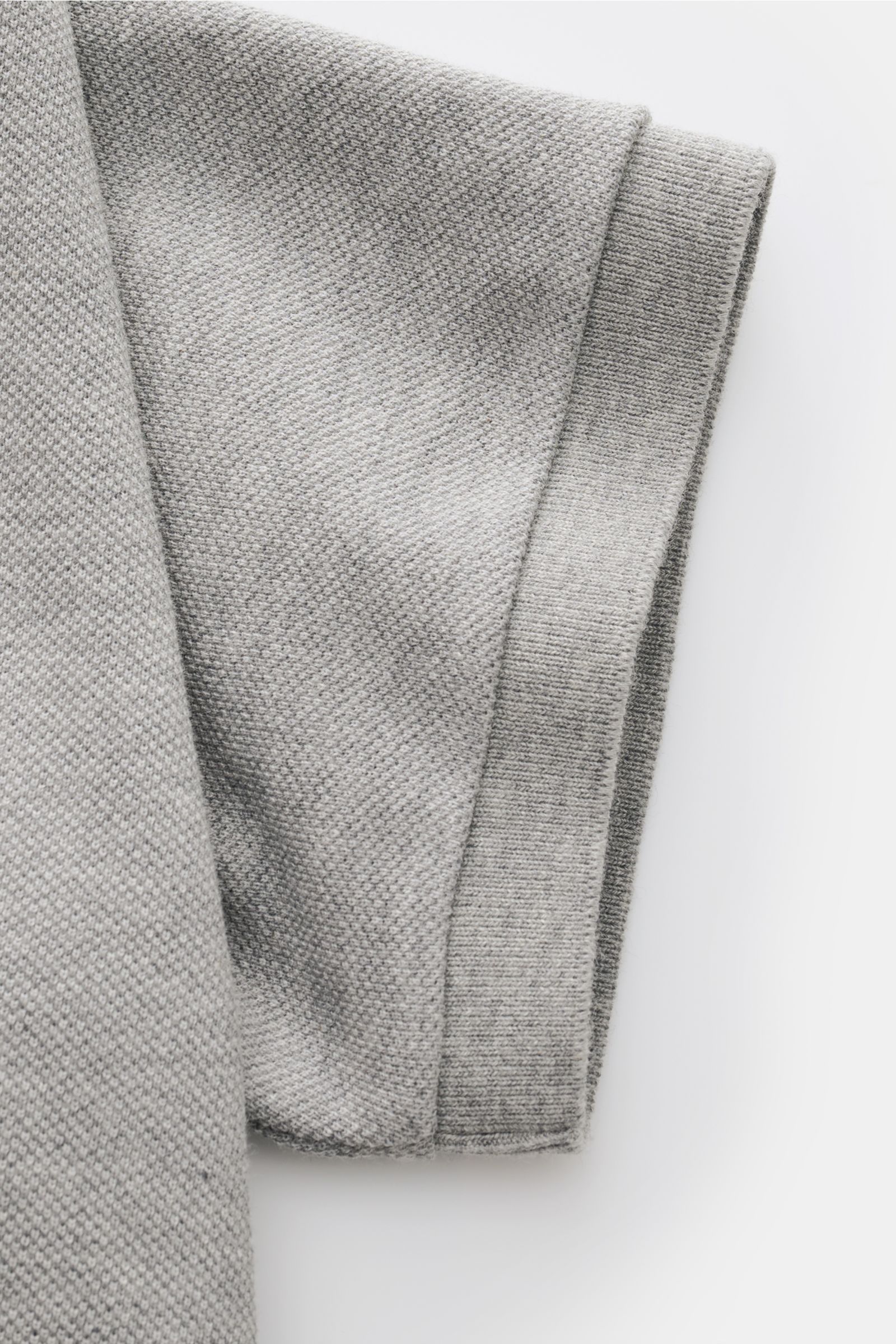 Close-up side view of the sleeve of a Thom Browne Polo shirt grey mottled, showing pure cotton texture and ribbed cuff details.