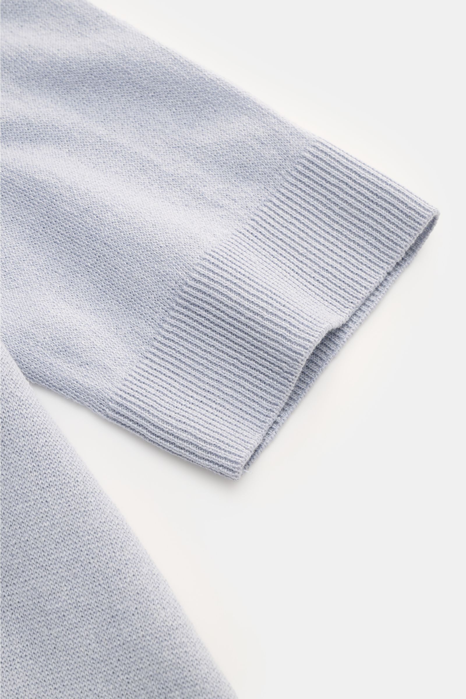 Close-up of the sleeve cuff of the Lardini Short sleeve knit polo smoky blue, photographed from above showing fine, airy knit texture. Elegance for the warmer seasons from LARDINI: This short-sleeved knit polo made from a linen and cotton blend in an airy