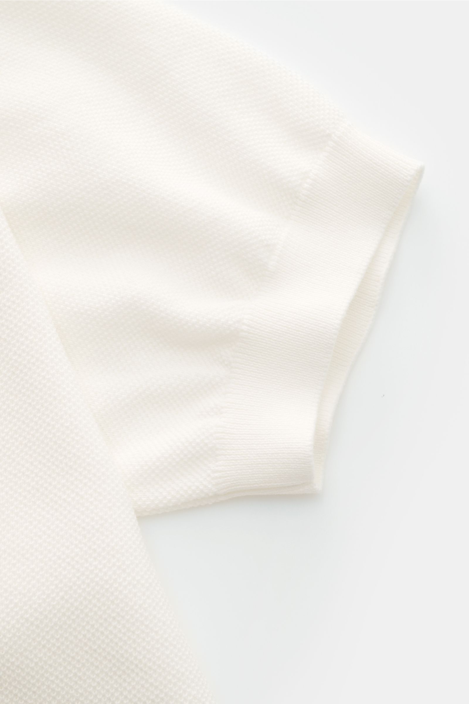 Lardini Kurzarm-Strickpolo offwhite aus reiner Baumwolle mit feinem Piqué-Strickmuster, Slim Fit, Polokragen und flexiblen Rippbündchen, Detailansicht Ärmel.